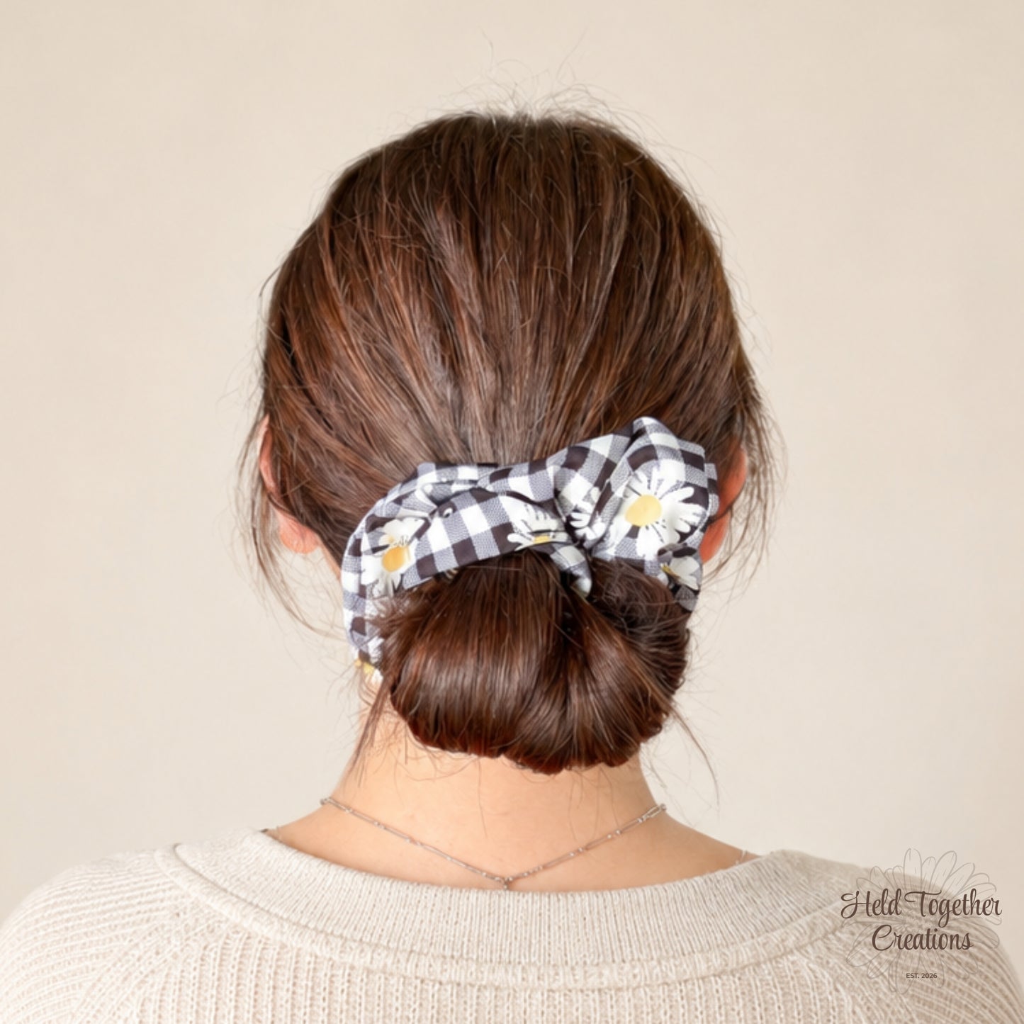 Handmade Daisy Check Scrunchie with black and white check fabric, white daisy print and yellow flower centres on a soft ivory background.