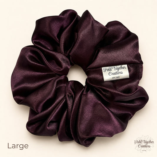 Large deep plum satin scrunchie on a warm ivory background