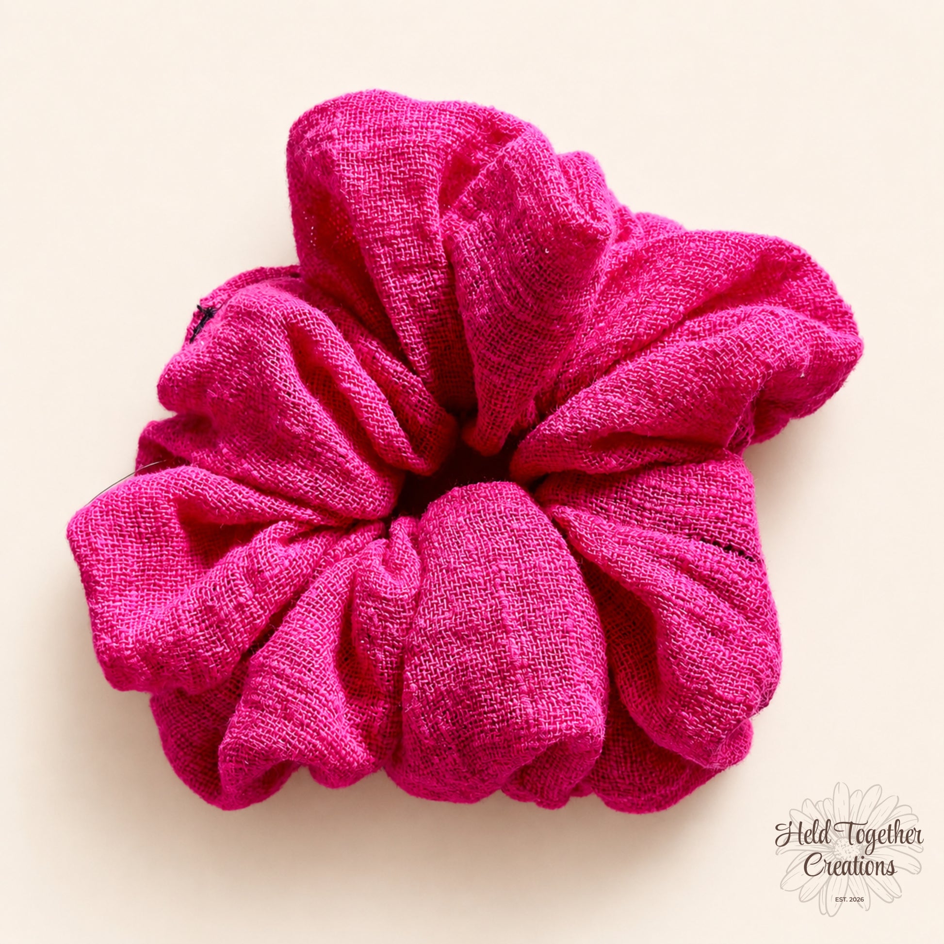 Berry pink handmade linen-look scrunchie on a warm ivory background.
