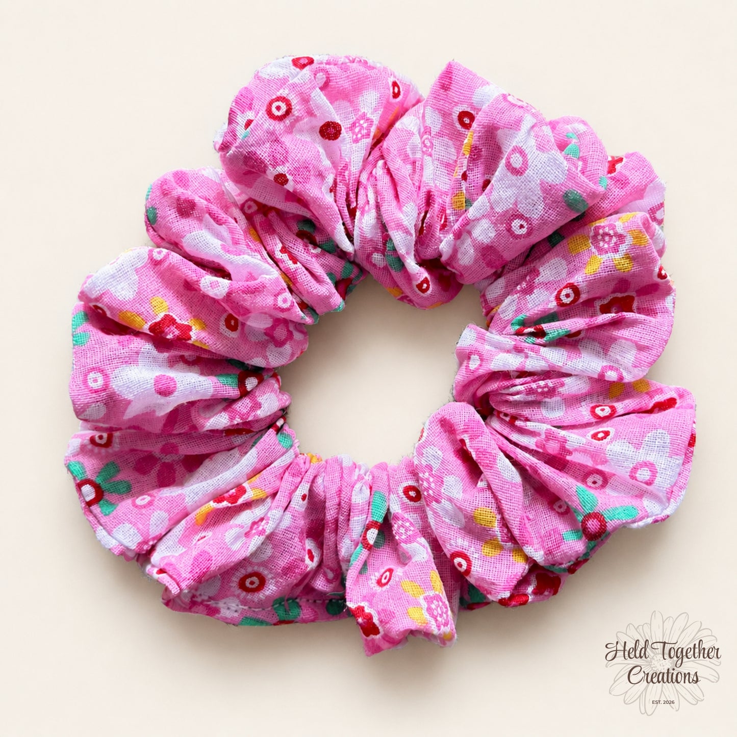 Pink floral scrunchie on a light beige background