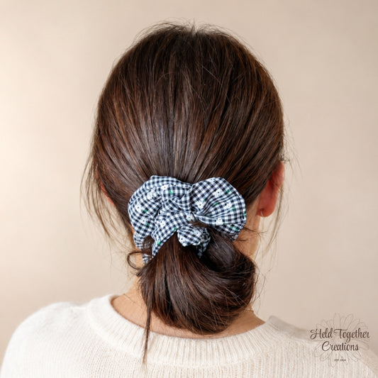 Black Gingham Garden Scrunchie worn in a low bun hairstyle against a soft neutral background.