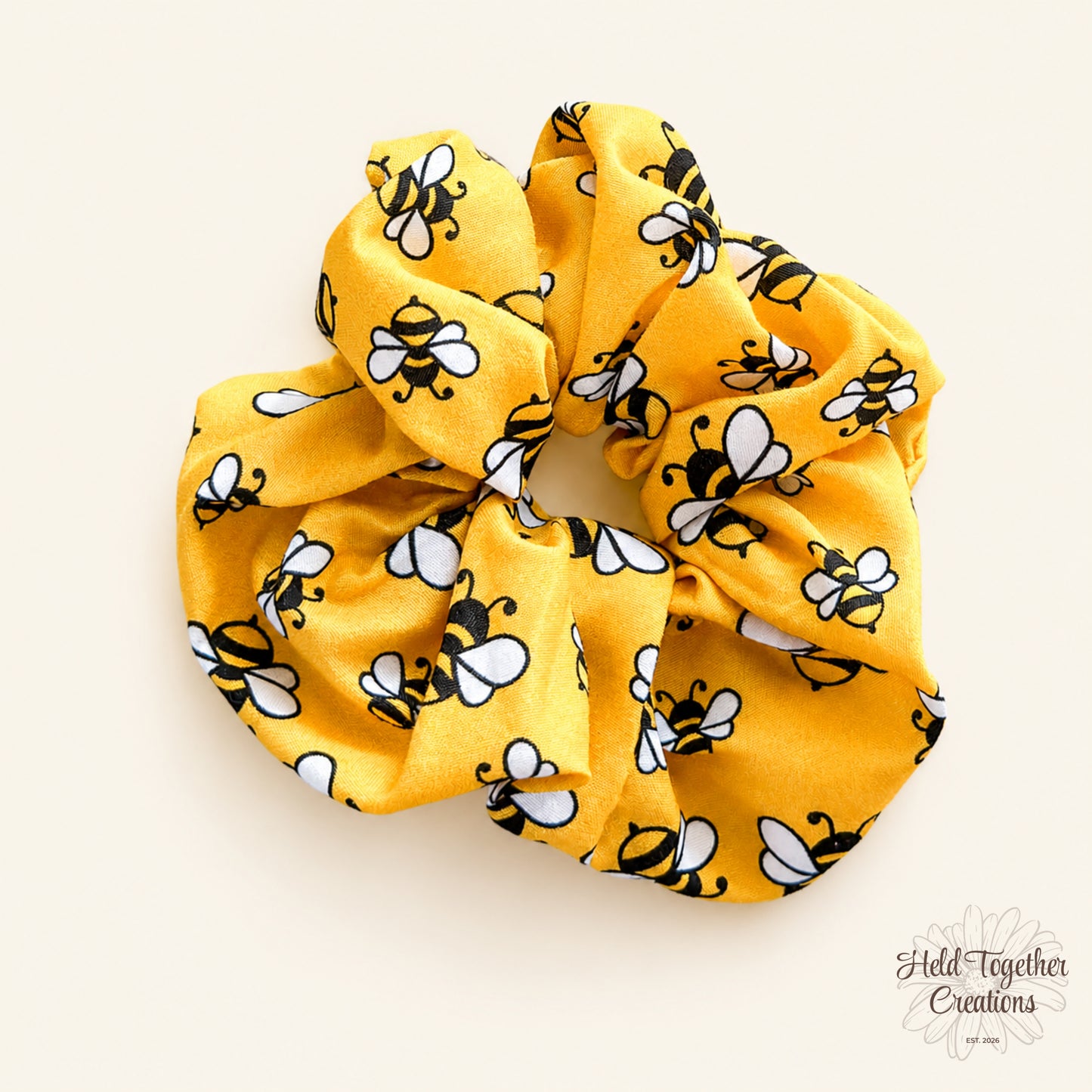 Yellow scrunchie with bee pattern on a white background
