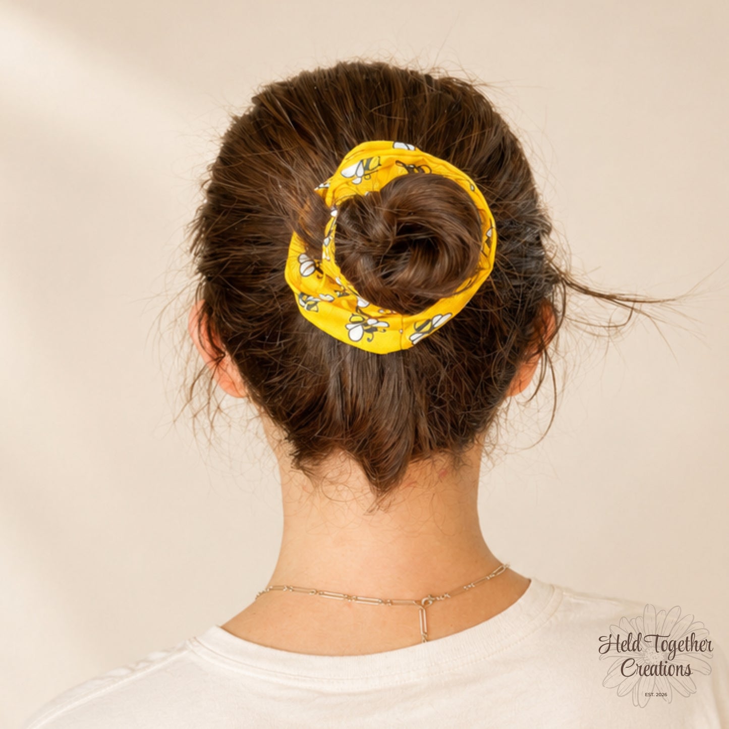 Yellow scrunchie with bee pattern on a white background