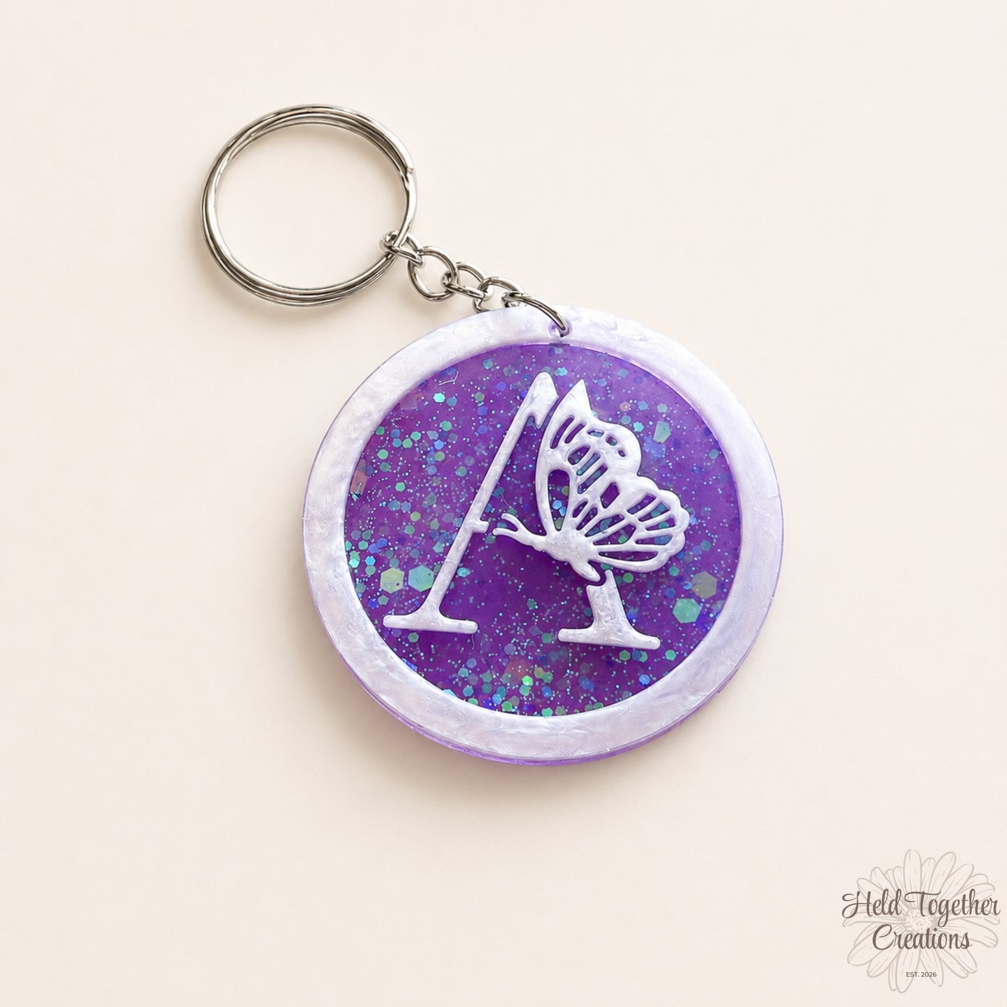 Keychain with butterfly design on a purple glittery background