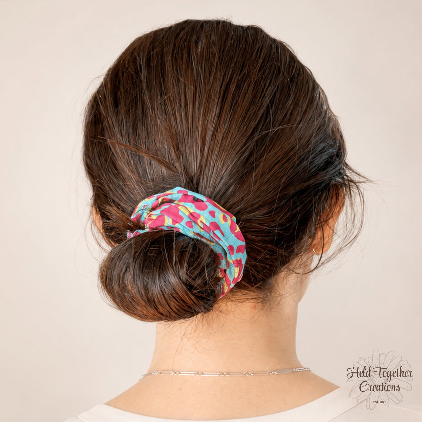 Bright blue, pink and yellow leopard print handmade fabric scrunchie by Held Together Creations.
