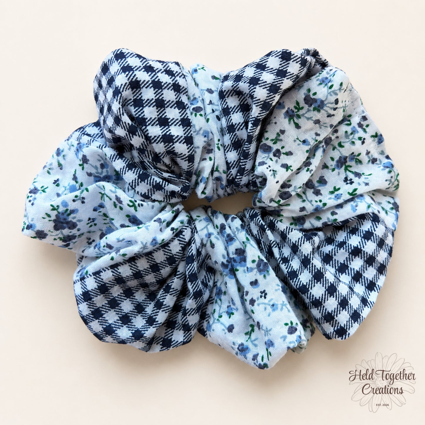 Handmade Checked Bloom Scrunchie with blue floral fabric and navy check fabric on a warm ivory background.