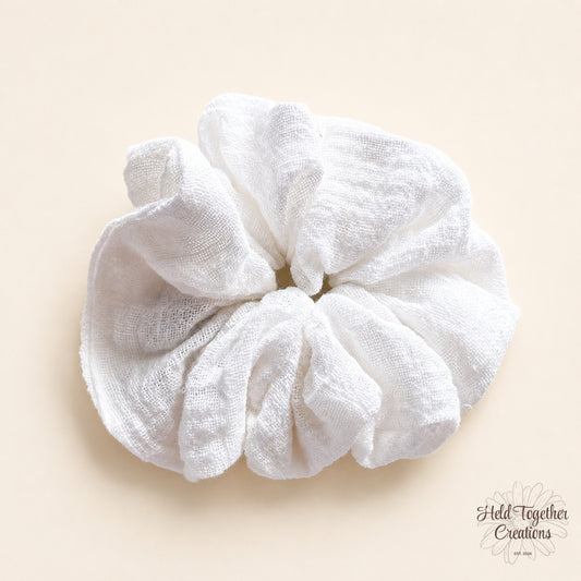 White textured linen-look scrunchie on a warm ivory background by Held Together Creations.