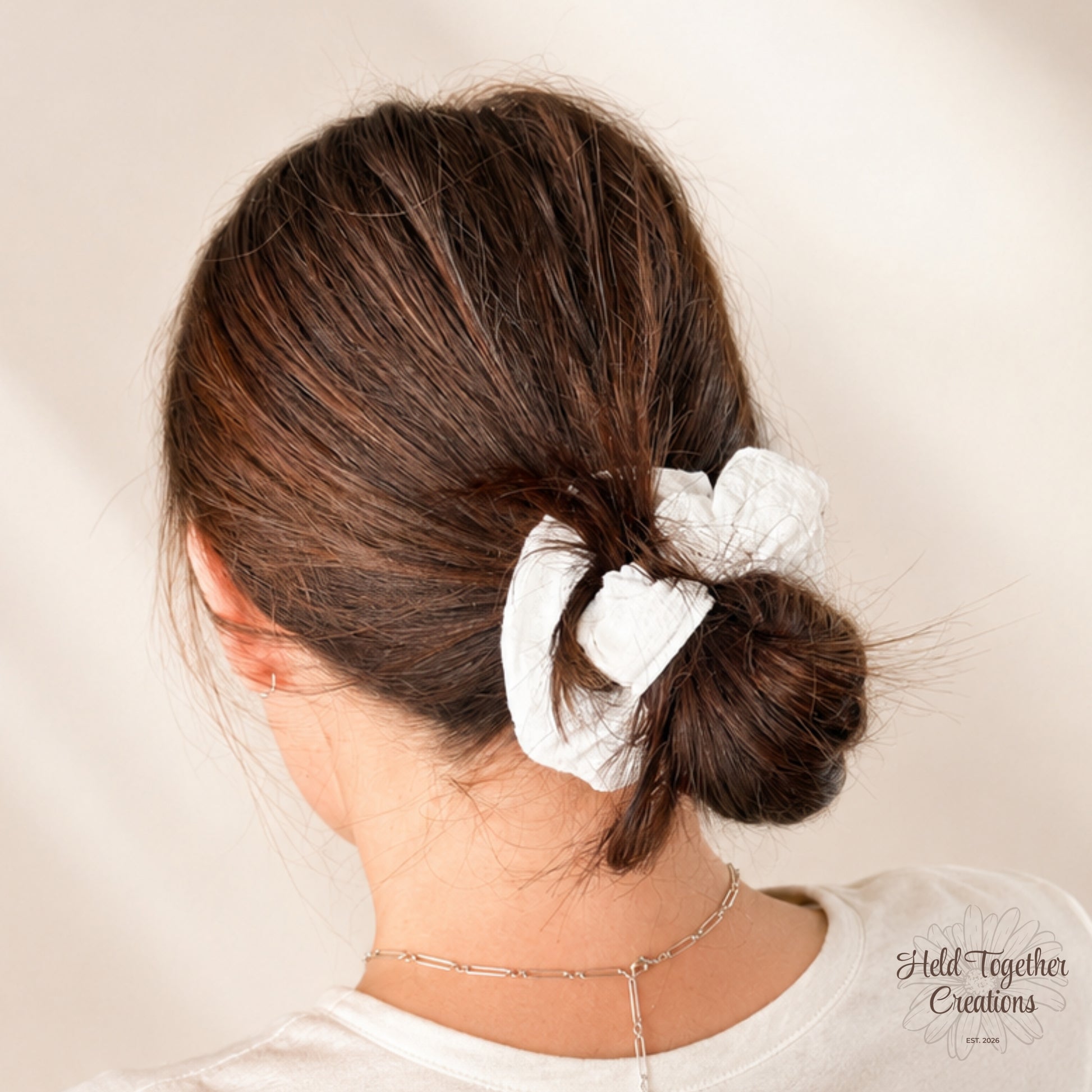 White textured linen-look scrunchie on a warm ivory background by Held Together Creations.