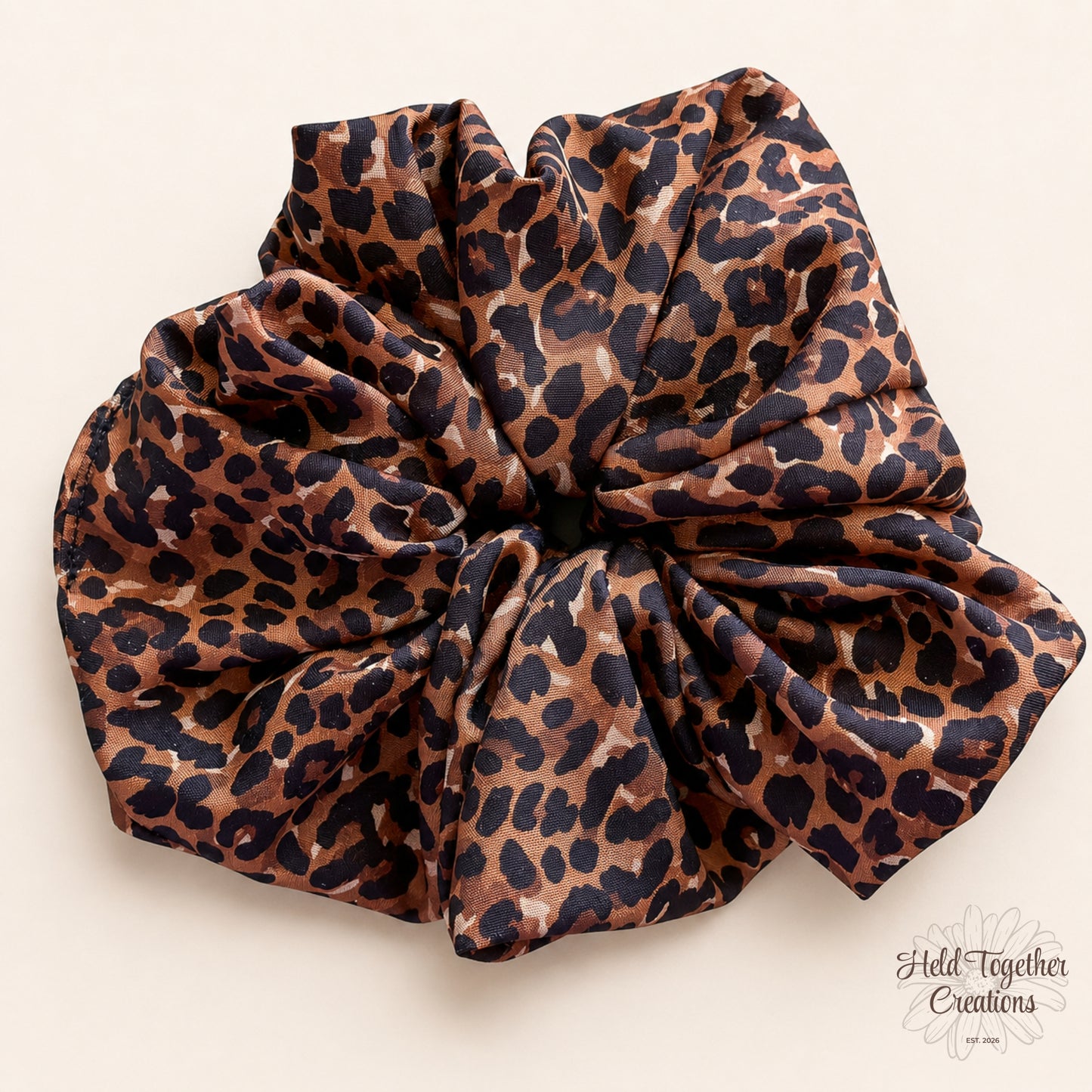 Cocoa brown leopard print handmade scrunchie on a warm ivory background.