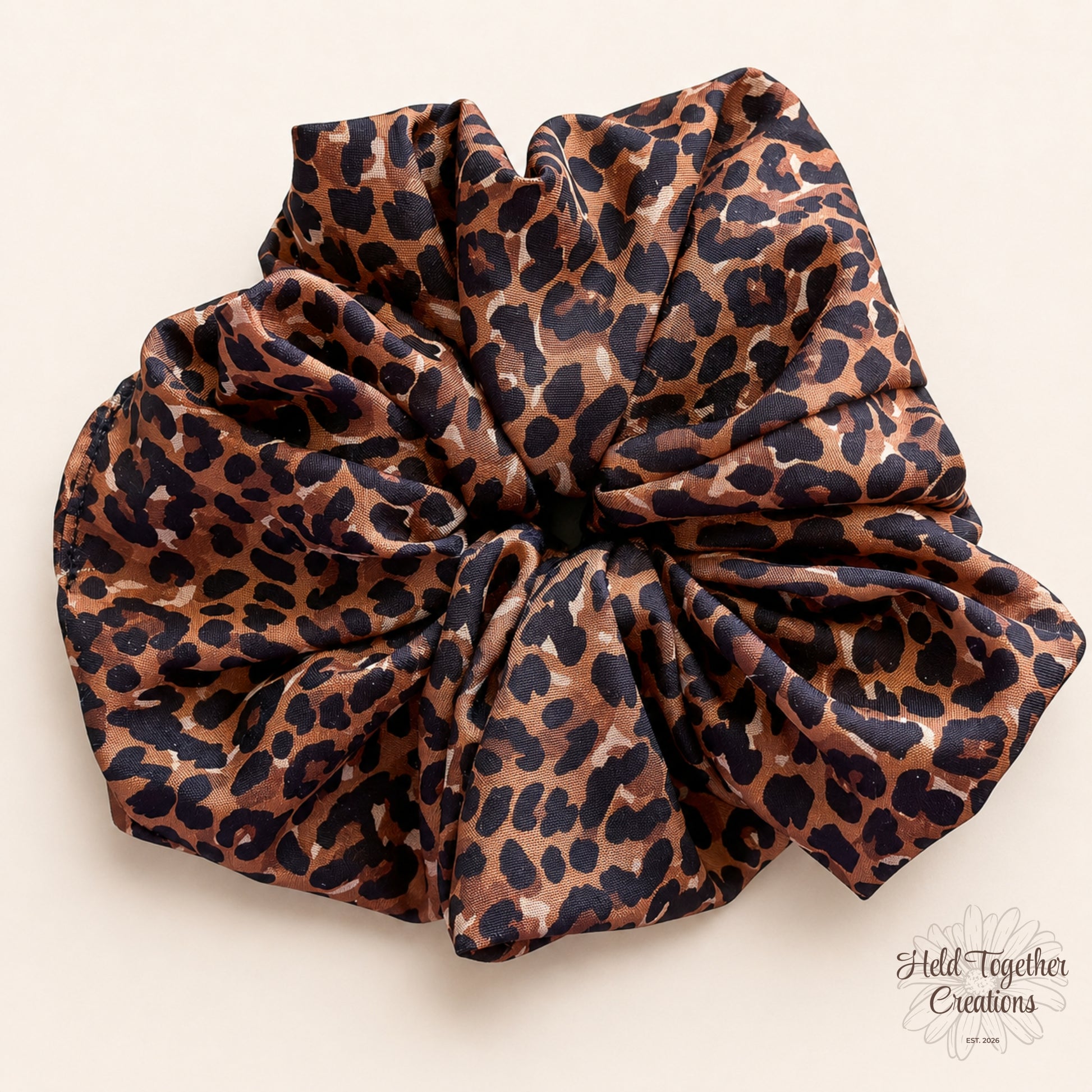 Cocoa brown leopard print handmade scrunchie on a warm ivory background.