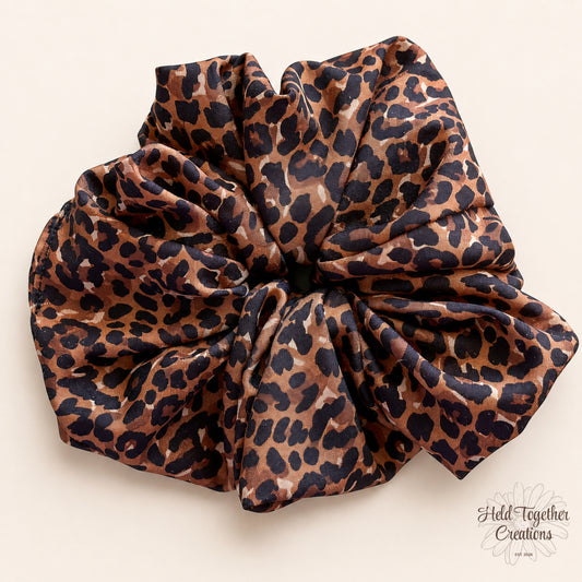Cocoa brown leopard print handmade scrunchie on a warm ivory background.