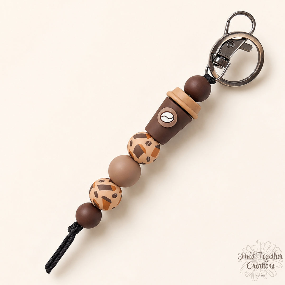 Coffee cup silicone bead keyring with brown and caramel silicone beads on a warm ivory background.