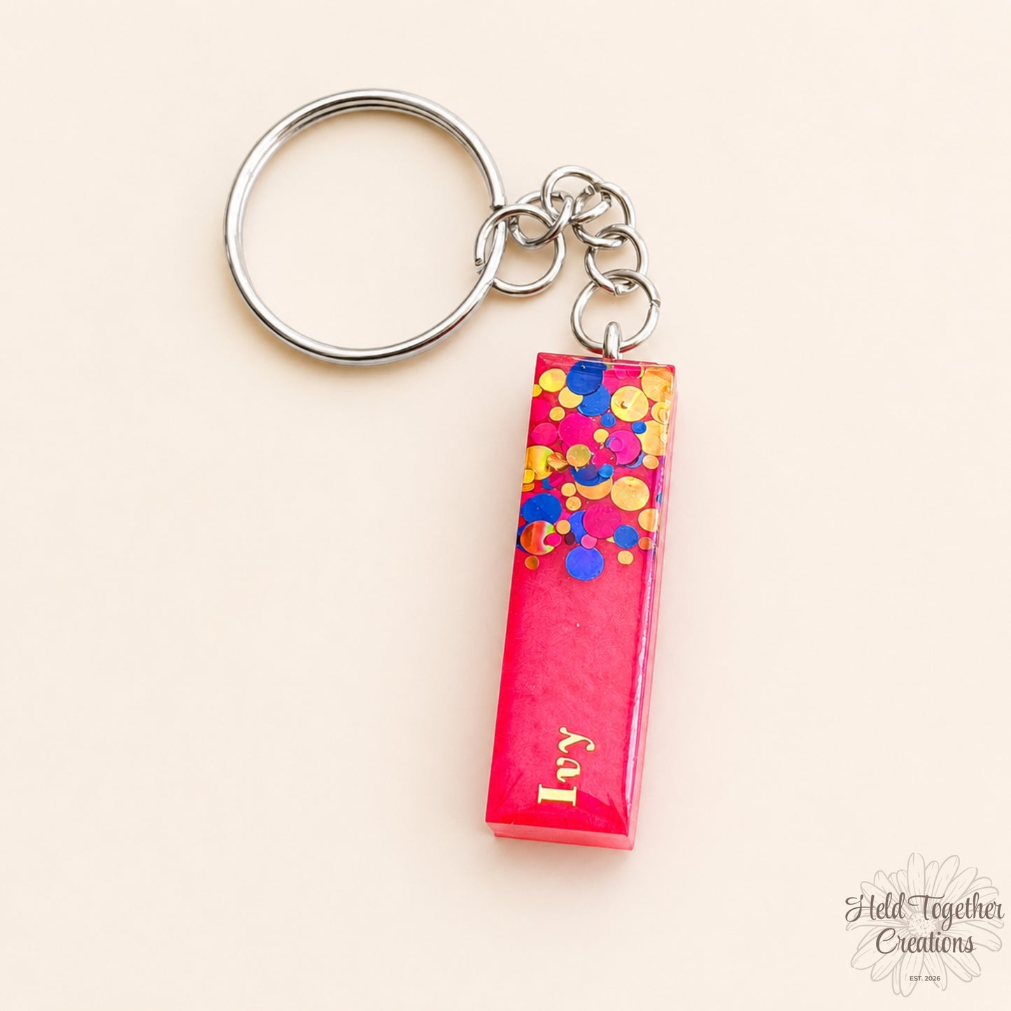 Keychain with colorful confetti design on a pink background