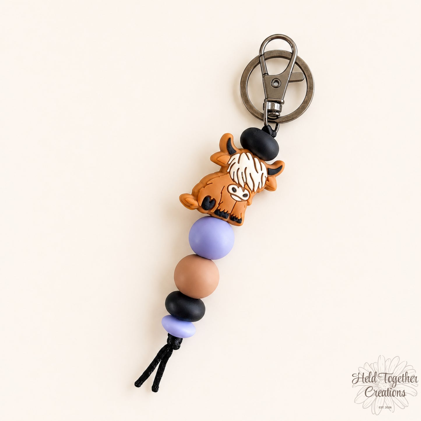 Handmade highland cow silicone bead keyrings with soft silicone beads and black keyring hardware on a neutral background.