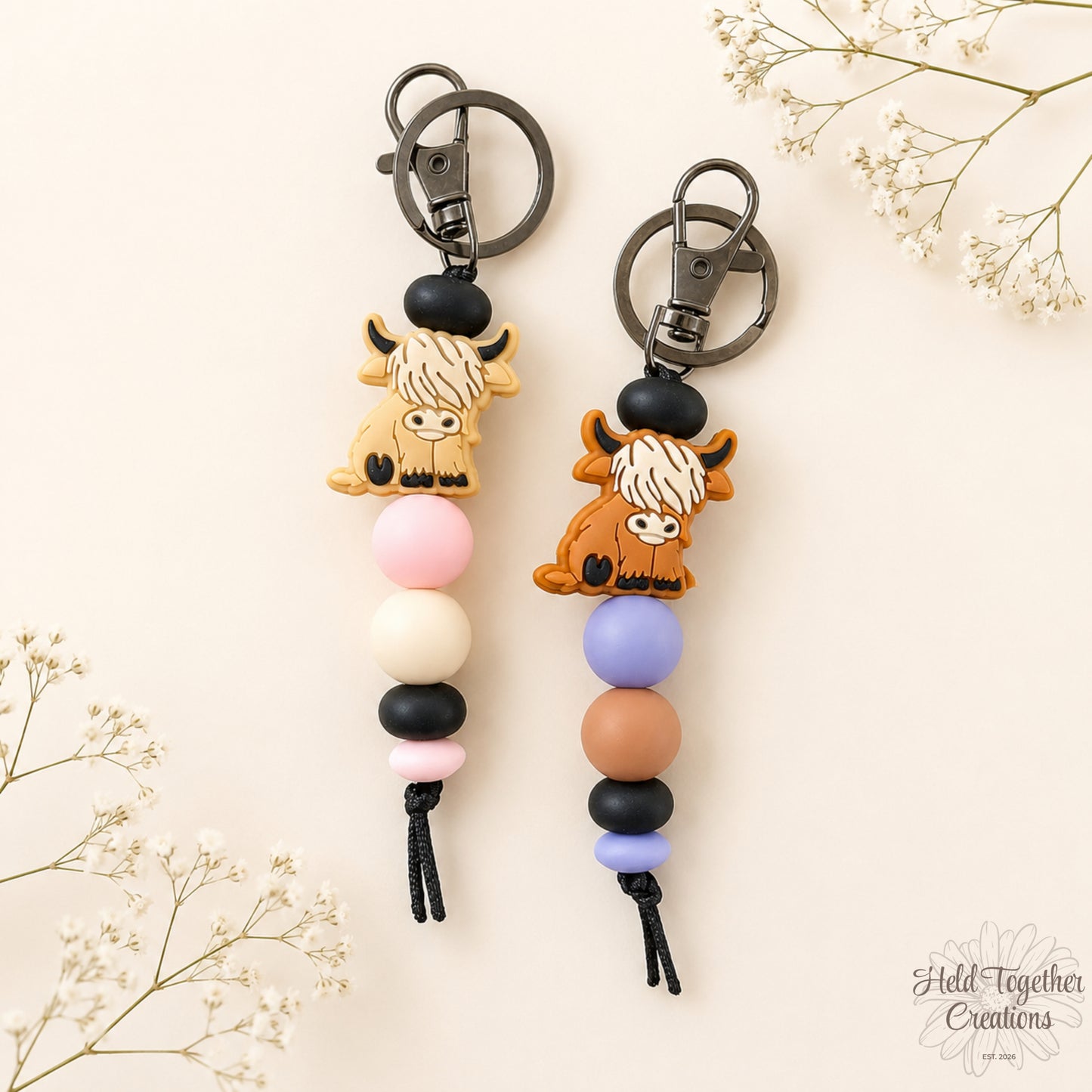Handmade highland cow silicone bead keyrings with soft silicone beads and black keyring hardware on a neutral background.