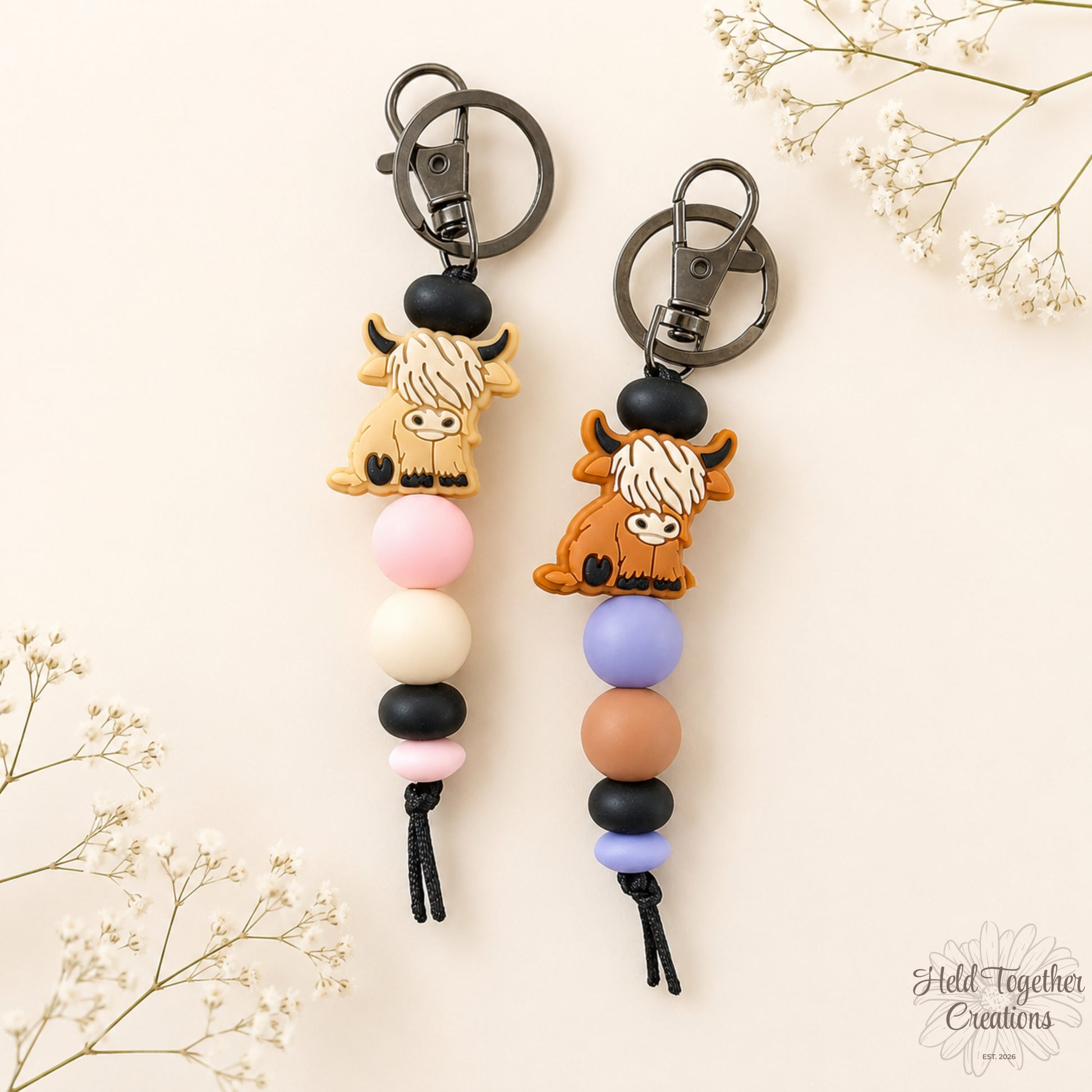 Handmade highland cow silicone bead keyrings with soft silicone beads and black keyring hardware on a neutral background.