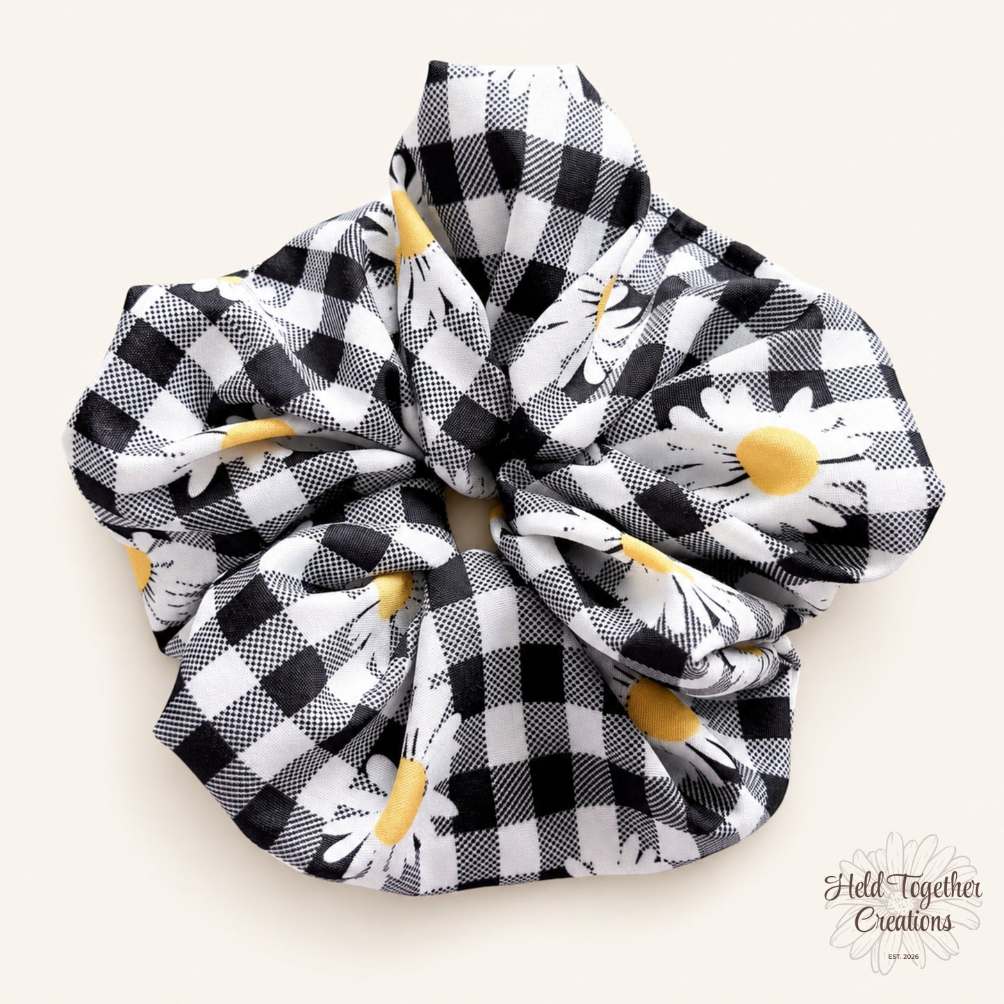 Handmade Daisy Check Scrunchie with black and white check fabric, white daisy print and yellow flower centres on a soft ivory background.