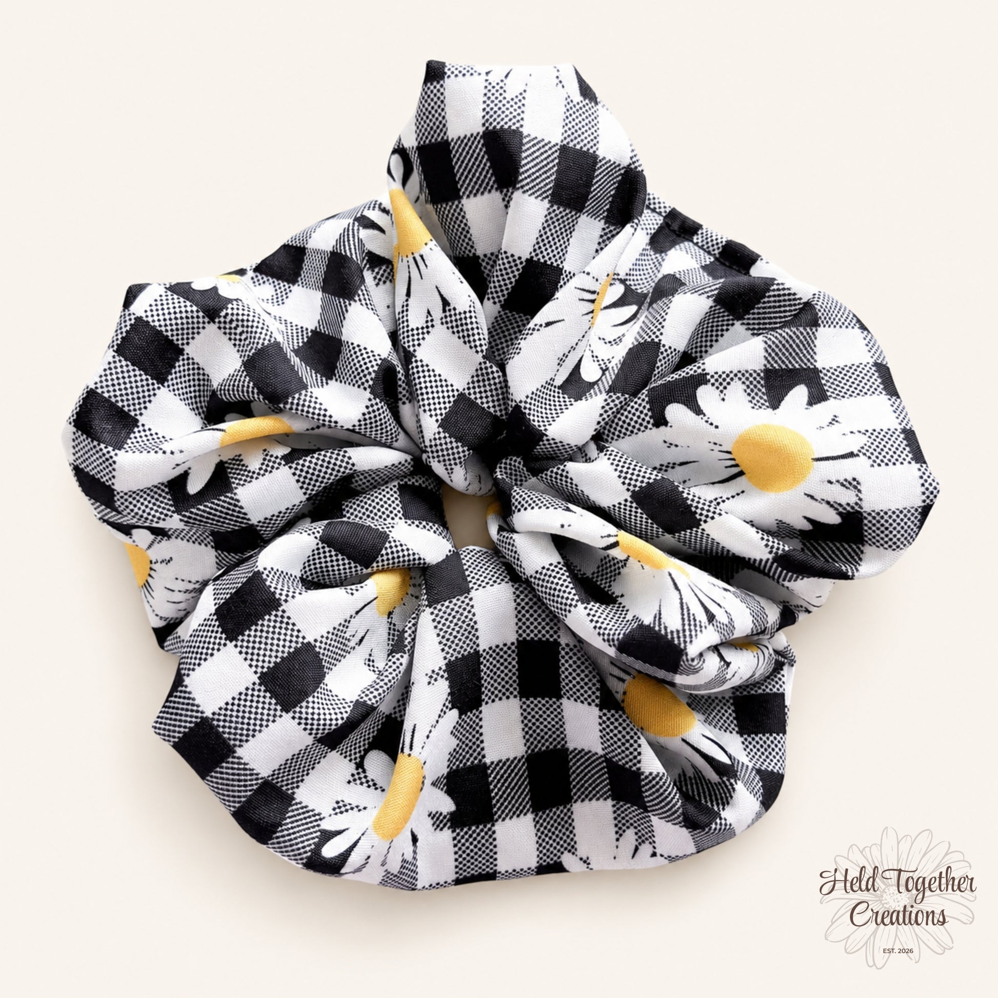 Handmade Daisy Check Scrunchie with black and white check fabric, white daisy print and yellow flower centres on a soft ivory background.