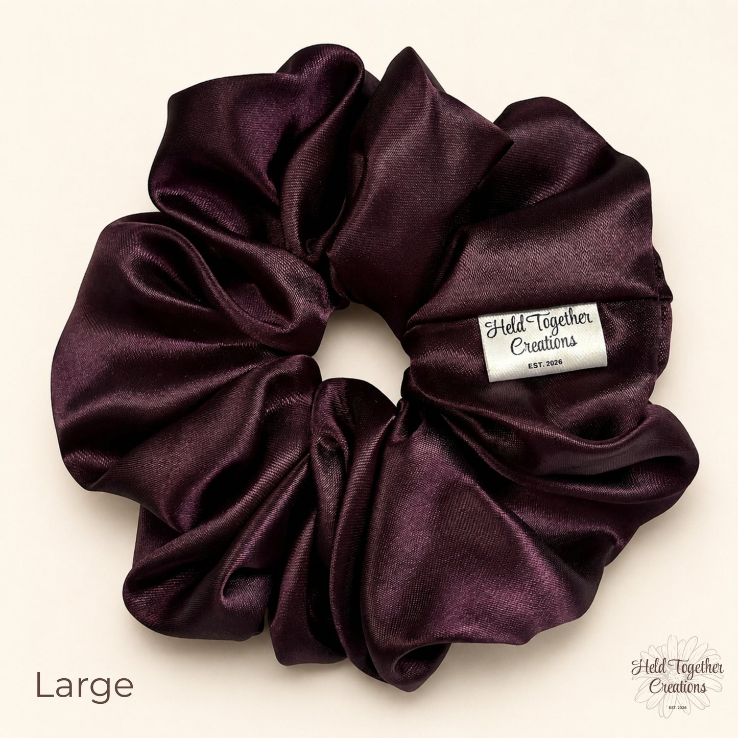 Large deep plum satin scrunchie on a warm ivory background