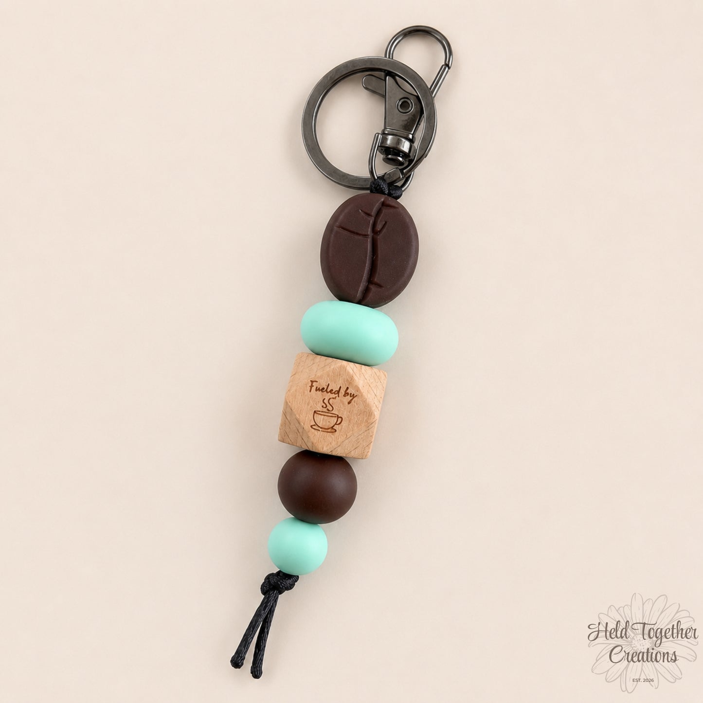 Keychain with beads and wooden tag on a beige background