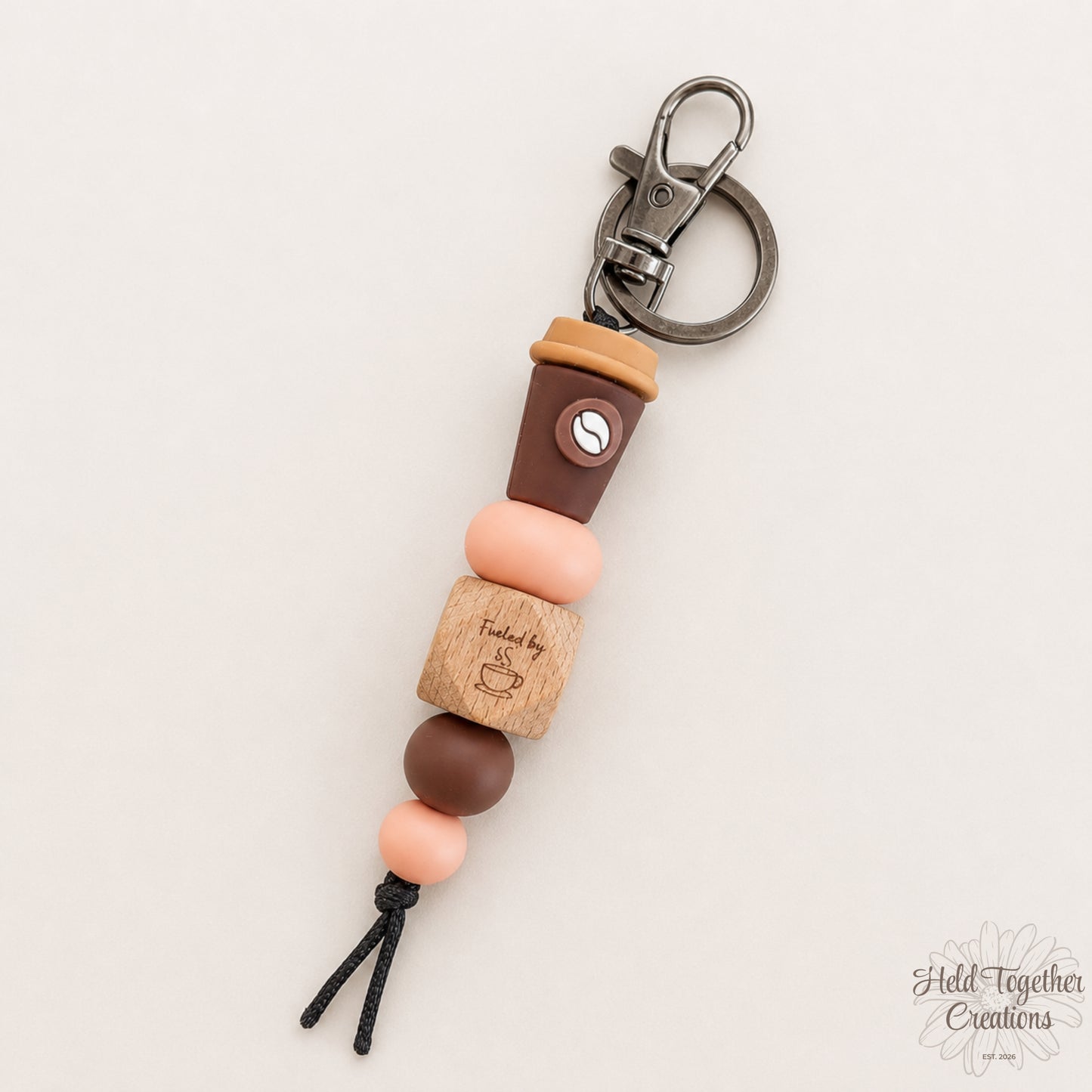 Keychain with coffee cup design on a beige background