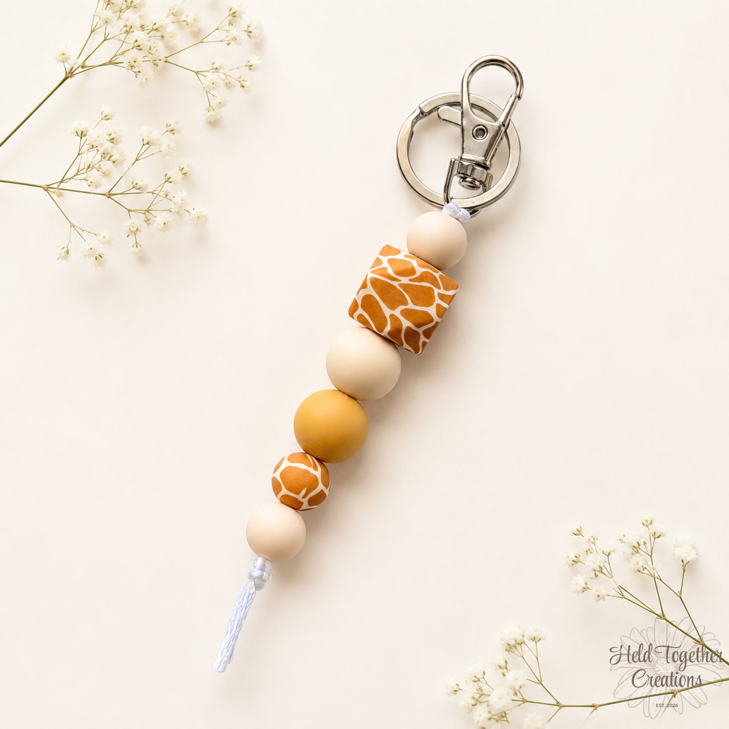 Handmade giraffe print silicone bead keyring with cream and tan beads on silver keyring hardware.