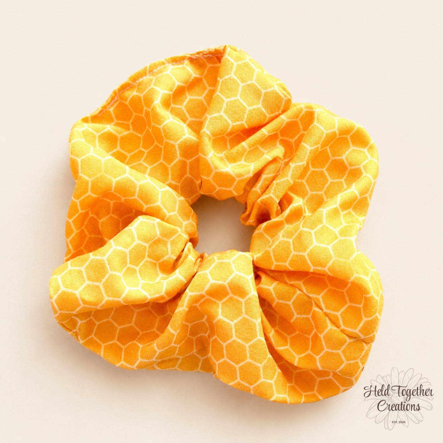 Yellow honeycomb patterned scrunchie on a light beige background