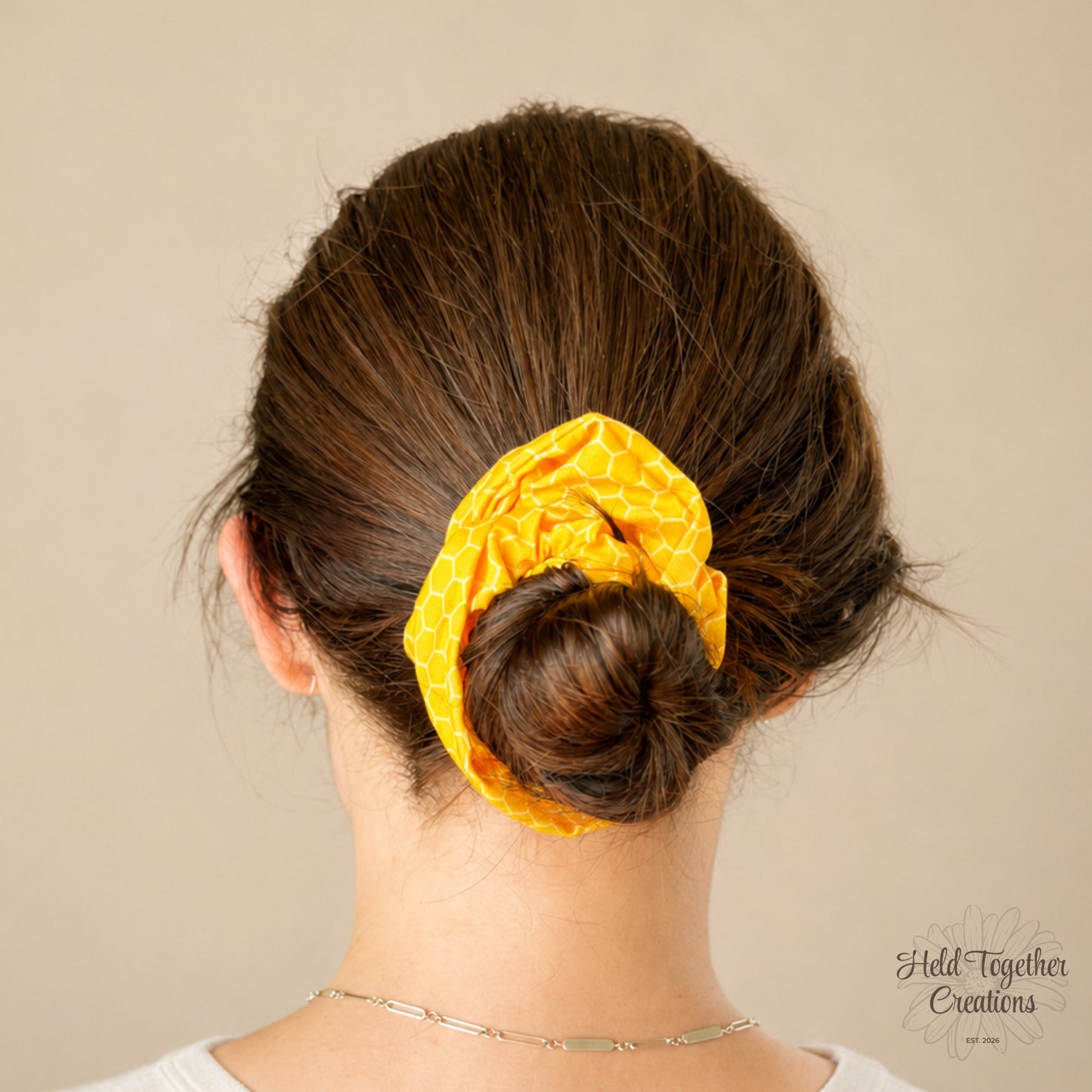 Yellow honeycomb patterned scrunchie on a light beige background