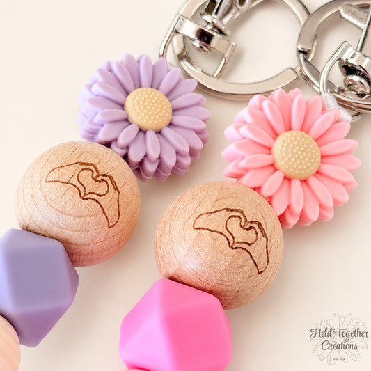 Pink and purple handmade Heart Hands silicone bead keyrings with daisy beads and silver keyring hardware.