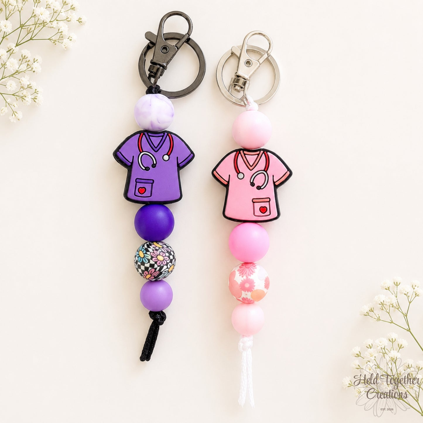 Handmade Healthcare Heroes silicone bead keyrings with purple and pink scrub charms, floral beads and metal keyring hardware.