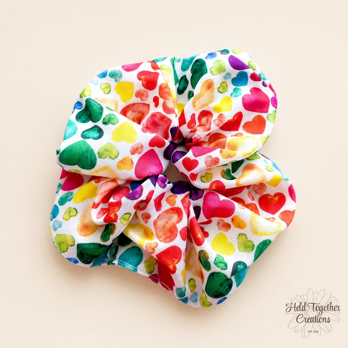 Handmade Heart Pop Scrunchie with colourful heart print on white fabric.