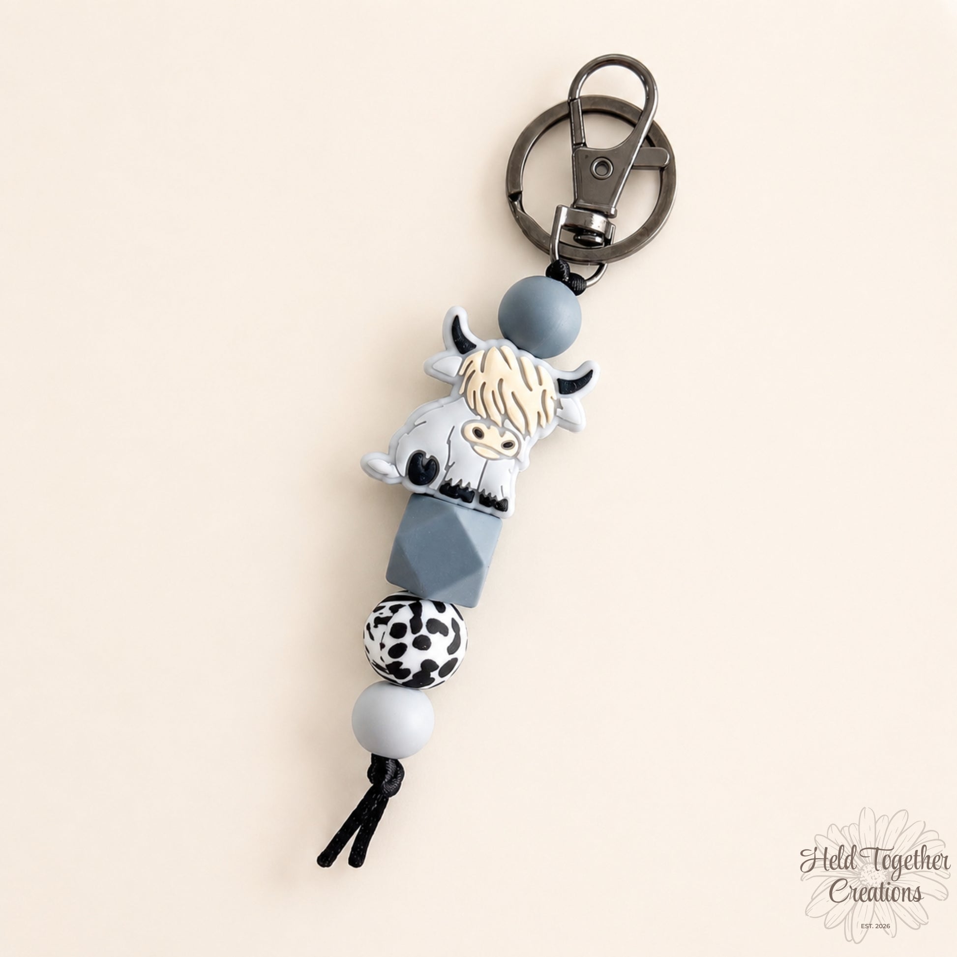 Keychain with cow design on a beige background