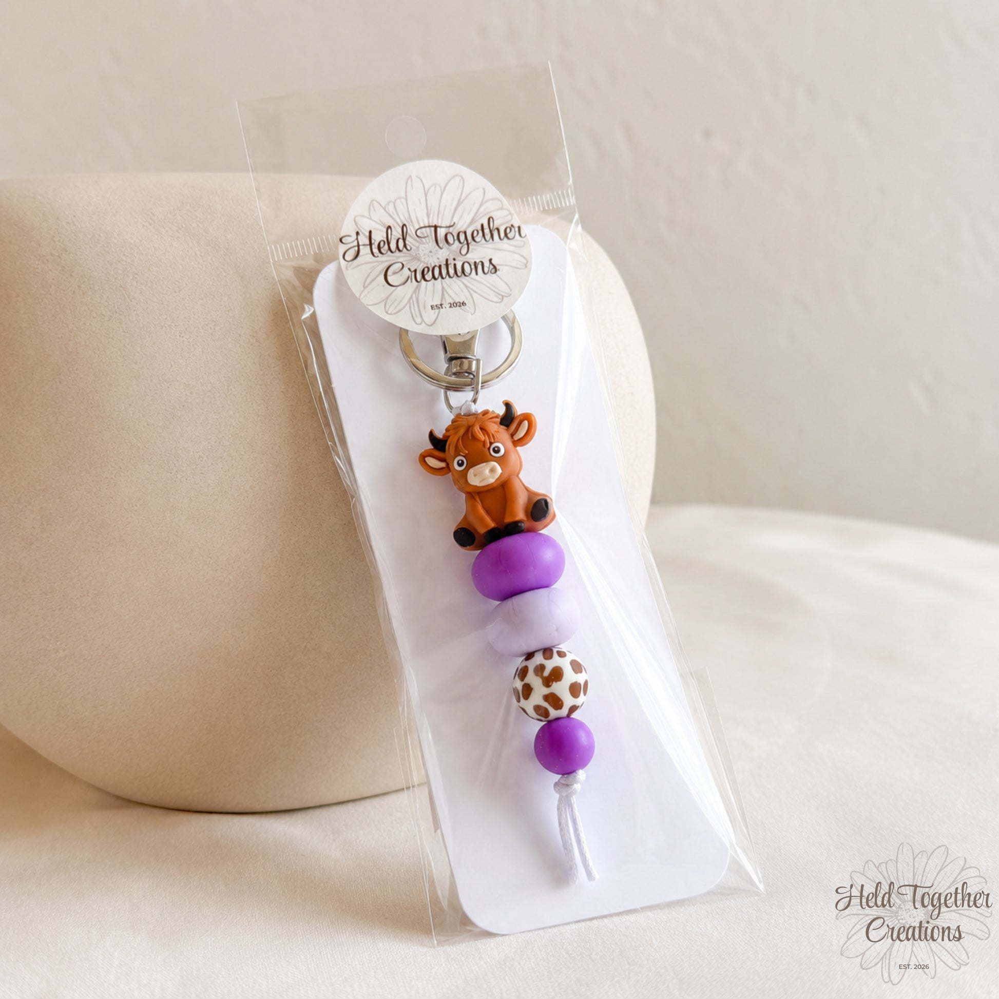 Keychain with animal design on a clear stand against a beige background