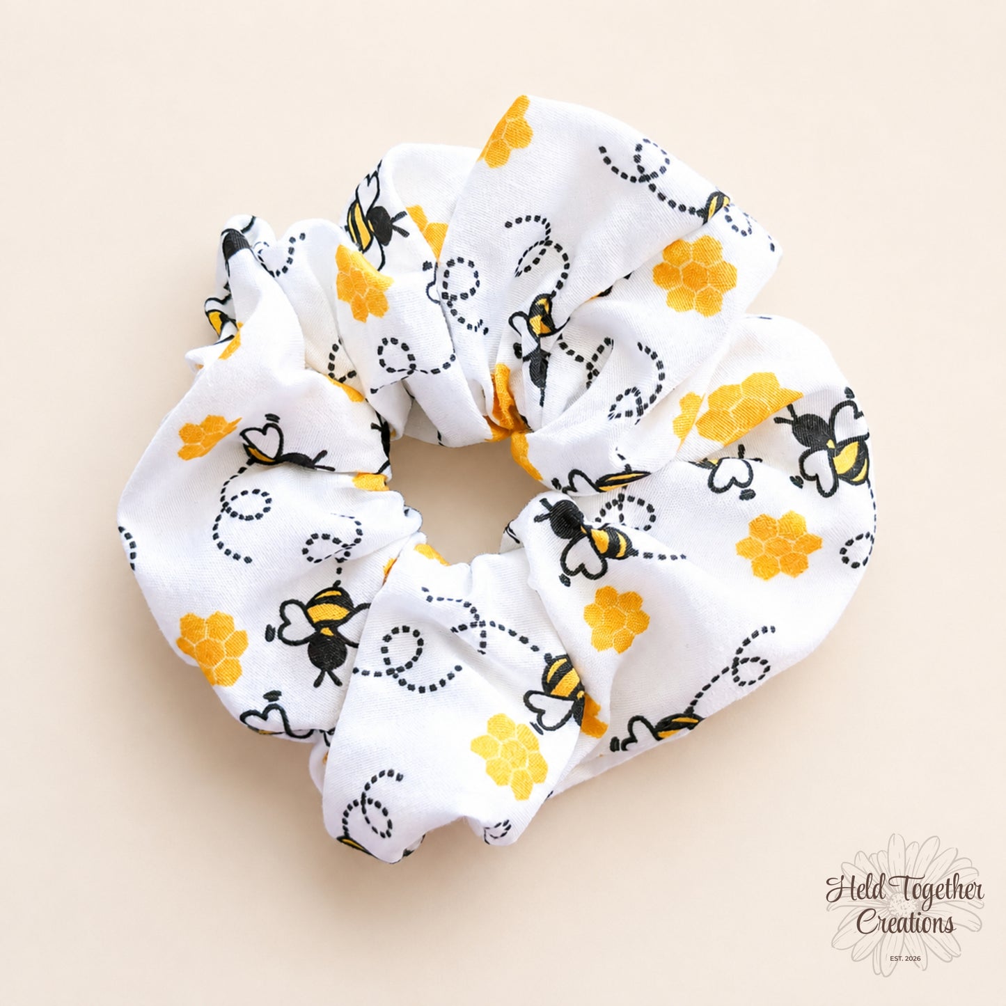 White scrunchie with bee and flower pattern on a beige background