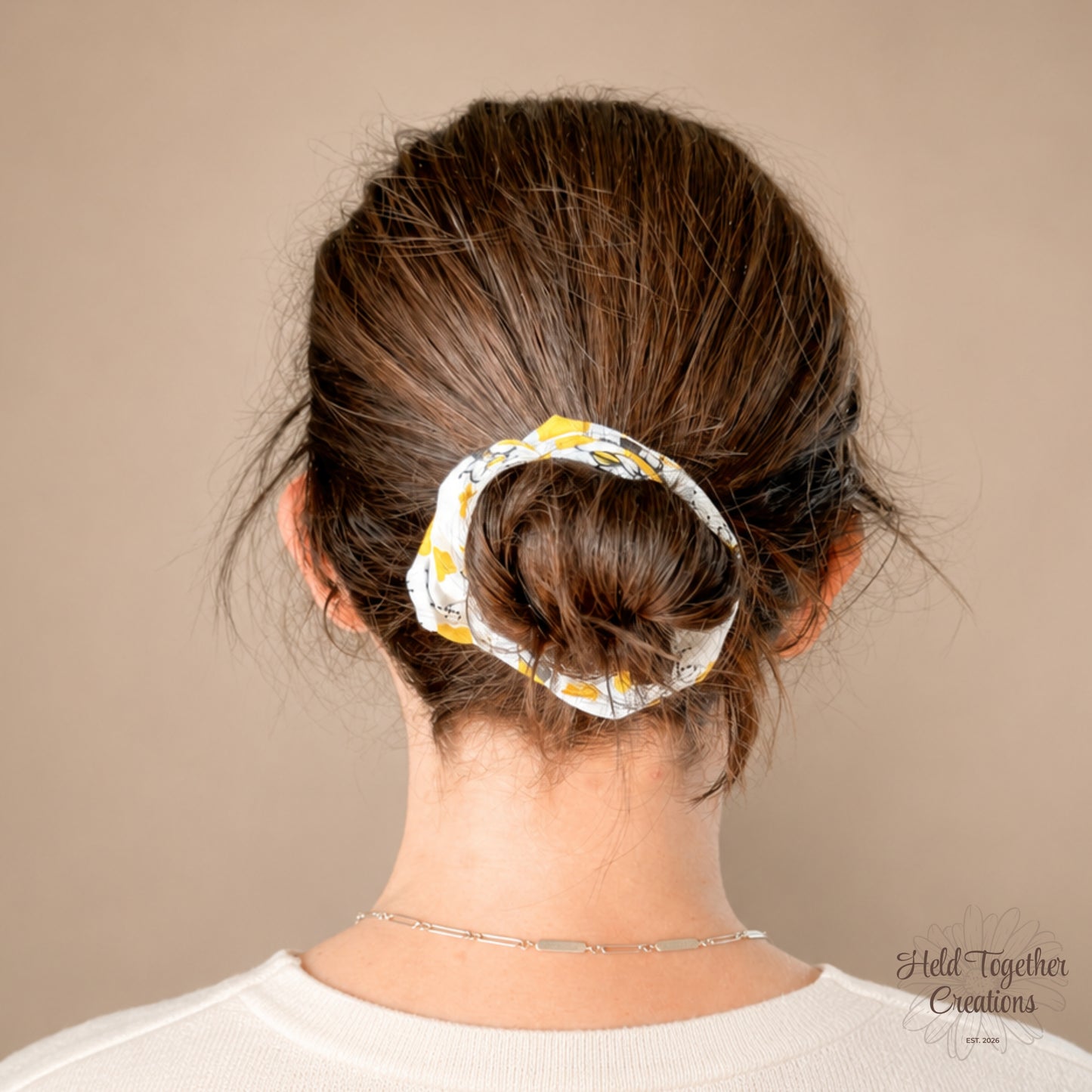 White scrunchie with bee and flower pattern on a beige background