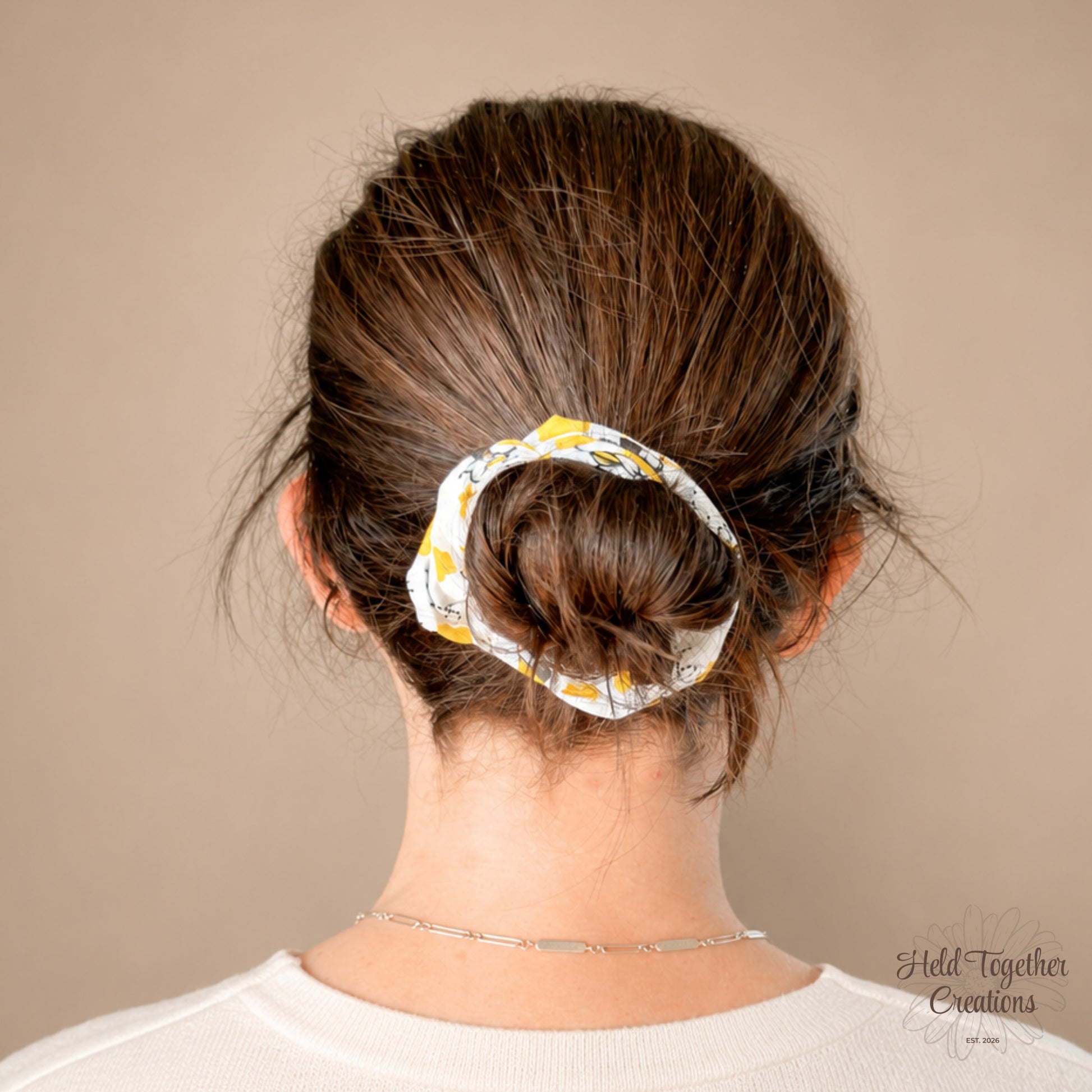 White scrunchie with bee and flower pattern on a beige background