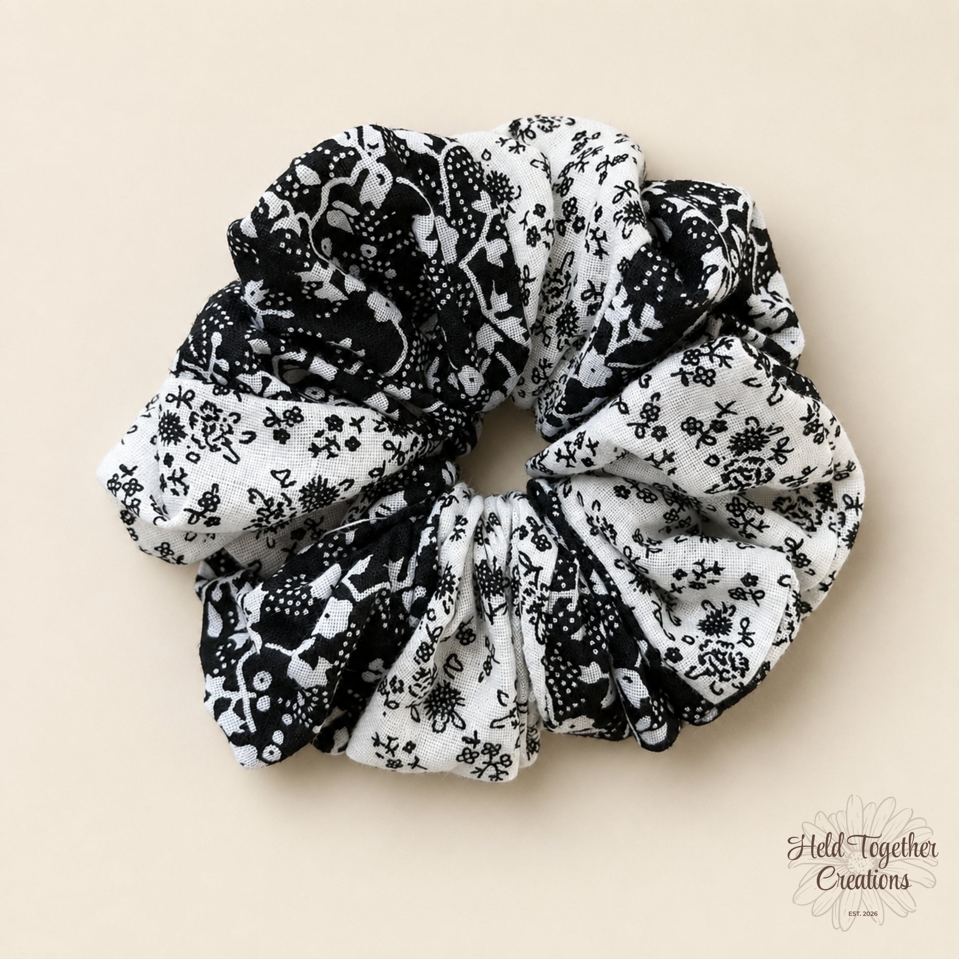 Ink Bloom Scrunchie with black and white floral print on a warm ivory background.
