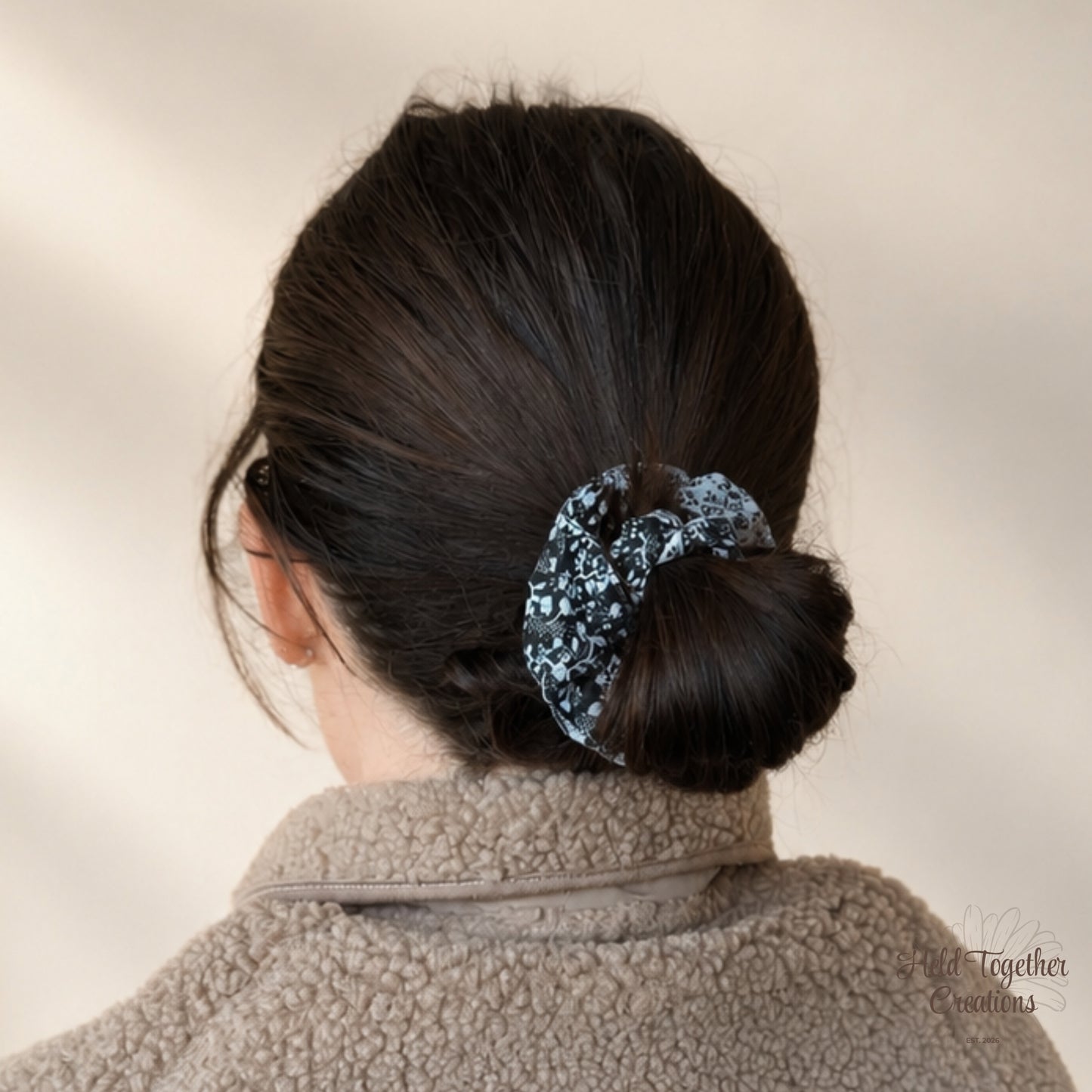 Black and white Ink Bloom Scrunchie worn around a low bun hairstyle.