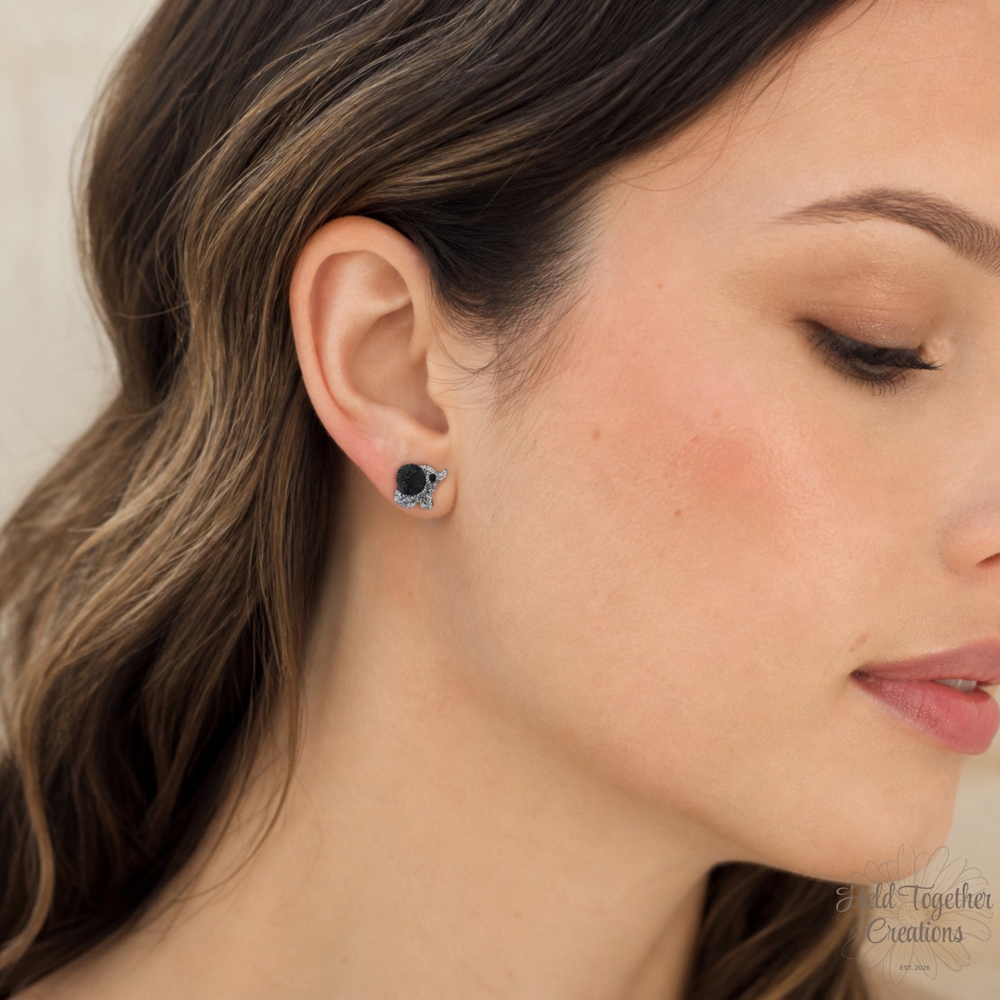 Handmade black and silver speckled elephant resin stud earrings on a soft neutral background.