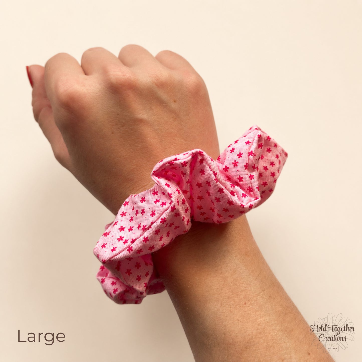Large Petal Sprinkle Scrunchie shown on wrist with pink floral fabric and soft gathered shape.
