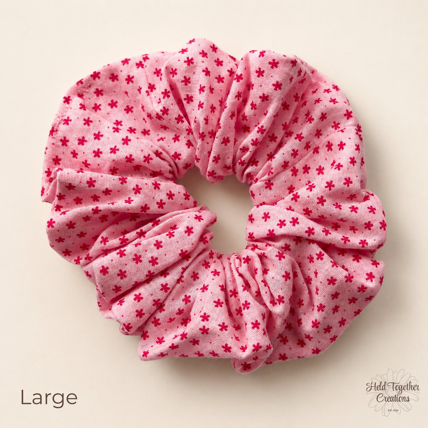 Large Petal Sprinkle Scrunchie laid flat on a warm ivory background showing pink fabric with deep pink mini floral print.
