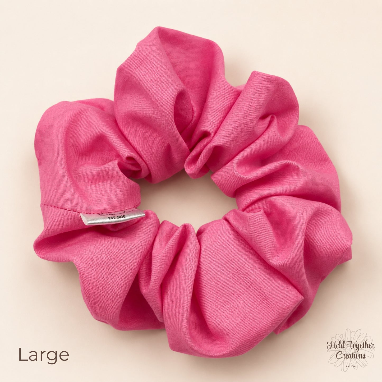 Large pink cotton scrunchie with gathered fabric and brand tag