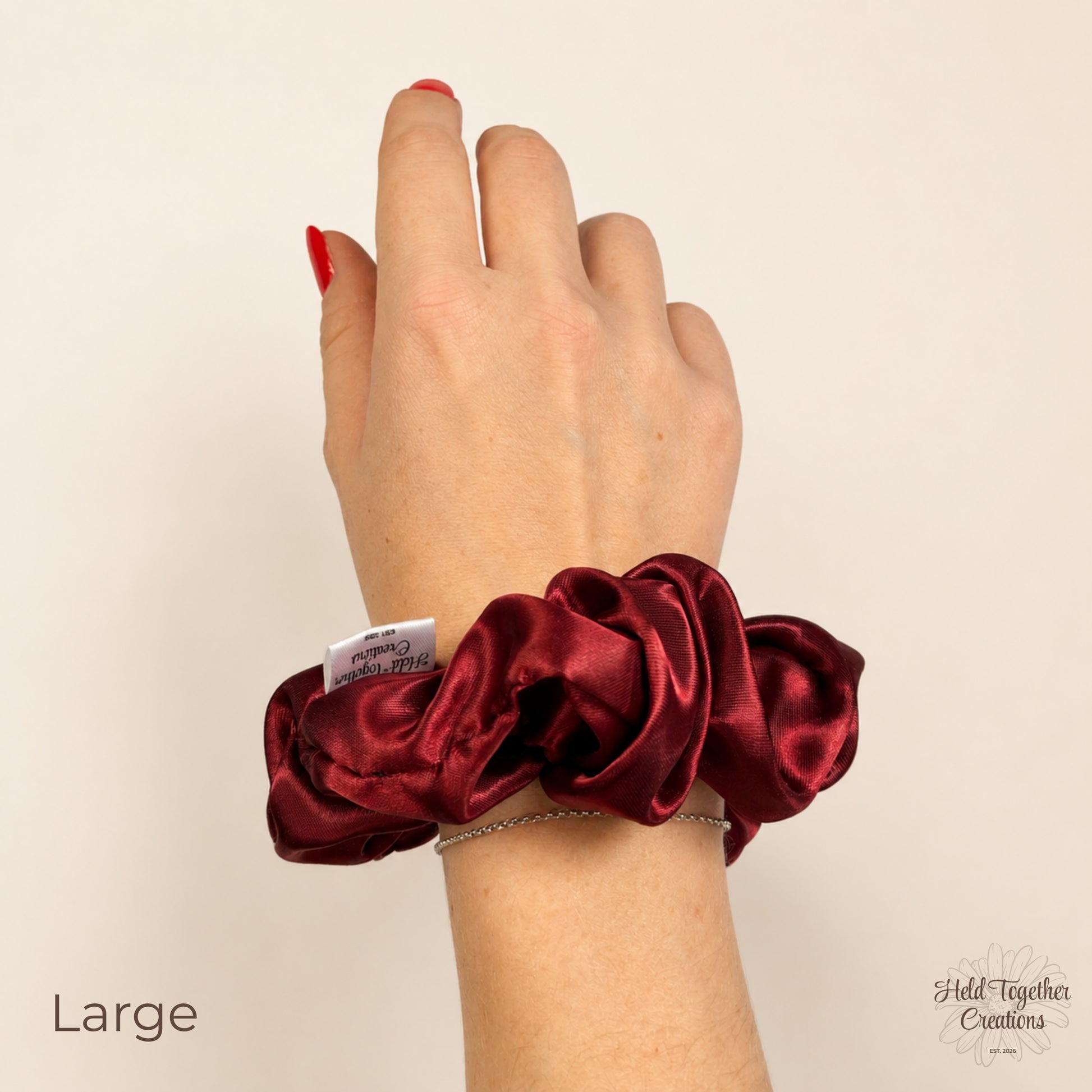 Large ruby satin scrunchie on wrist showing size and colour