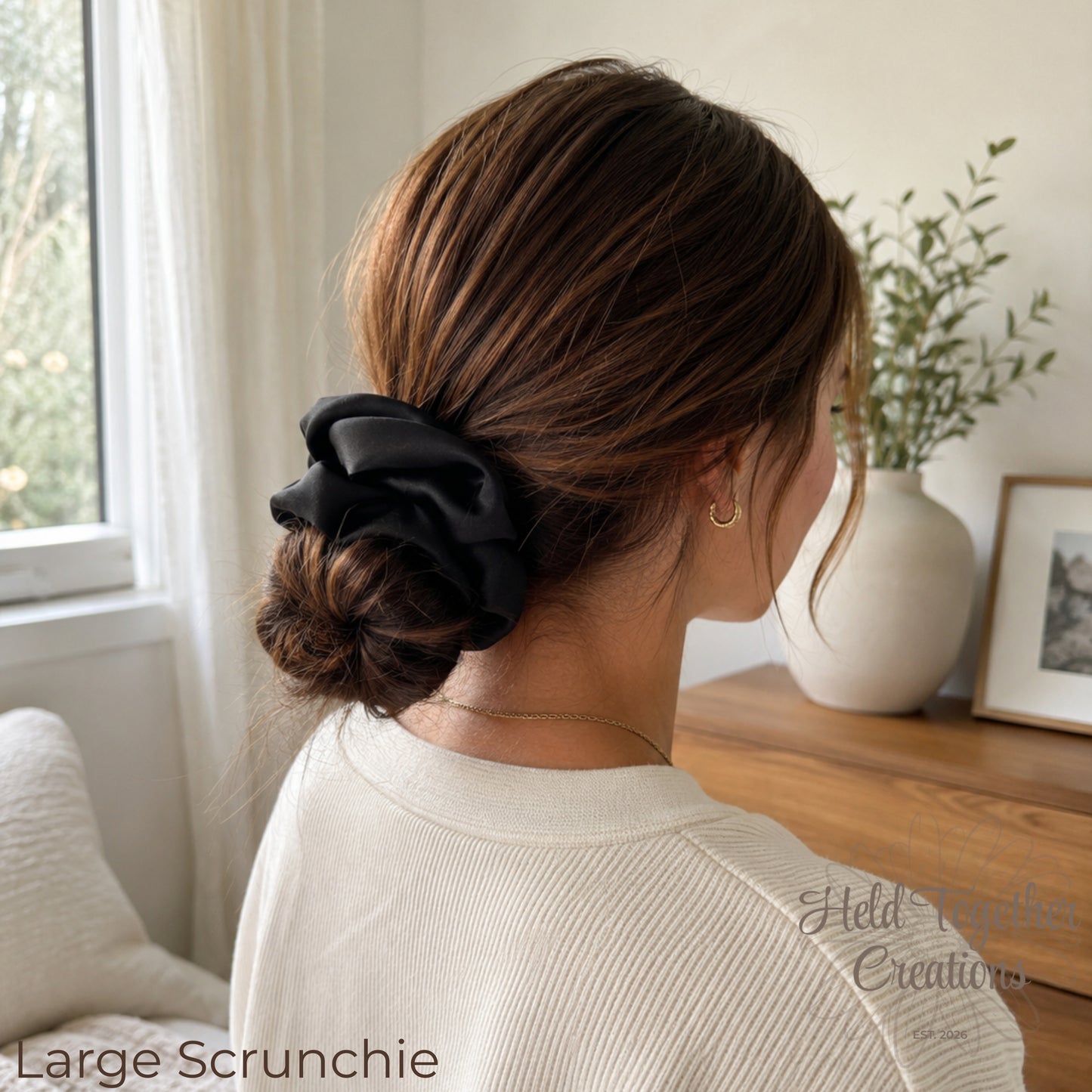 Black satin handmade scrunchies in large and small sizes on a soft neutral background.