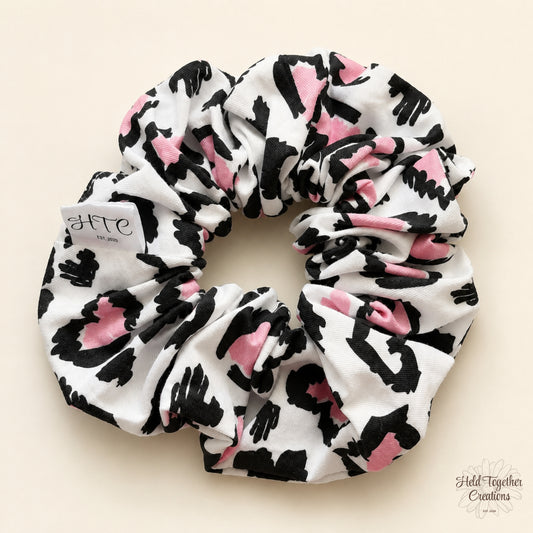 Handmade Leopard Love Scrunchie with black, white and pink leopard-inspired print on a soft neutral background.
