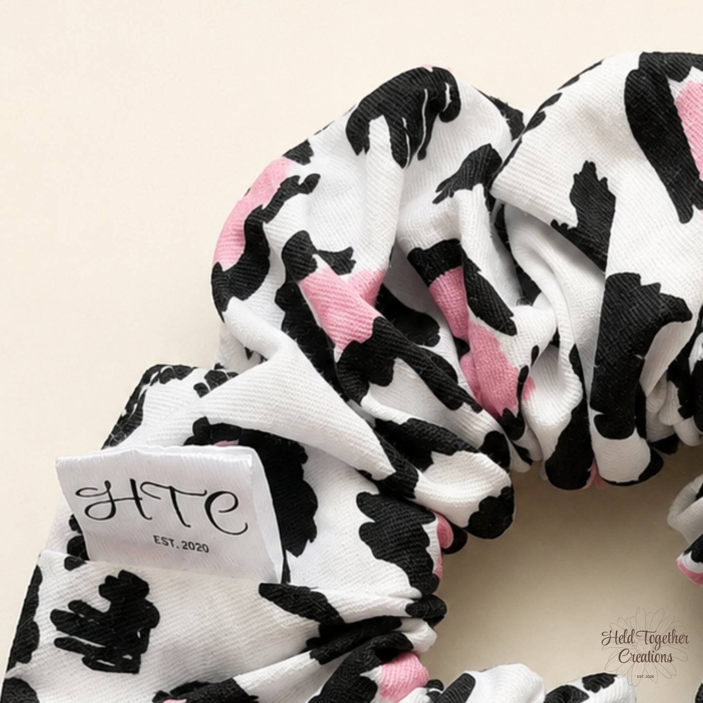 Close-up of Leopard Love Scrunchie showing textured fabric, black leopard-inspired print and pink details.