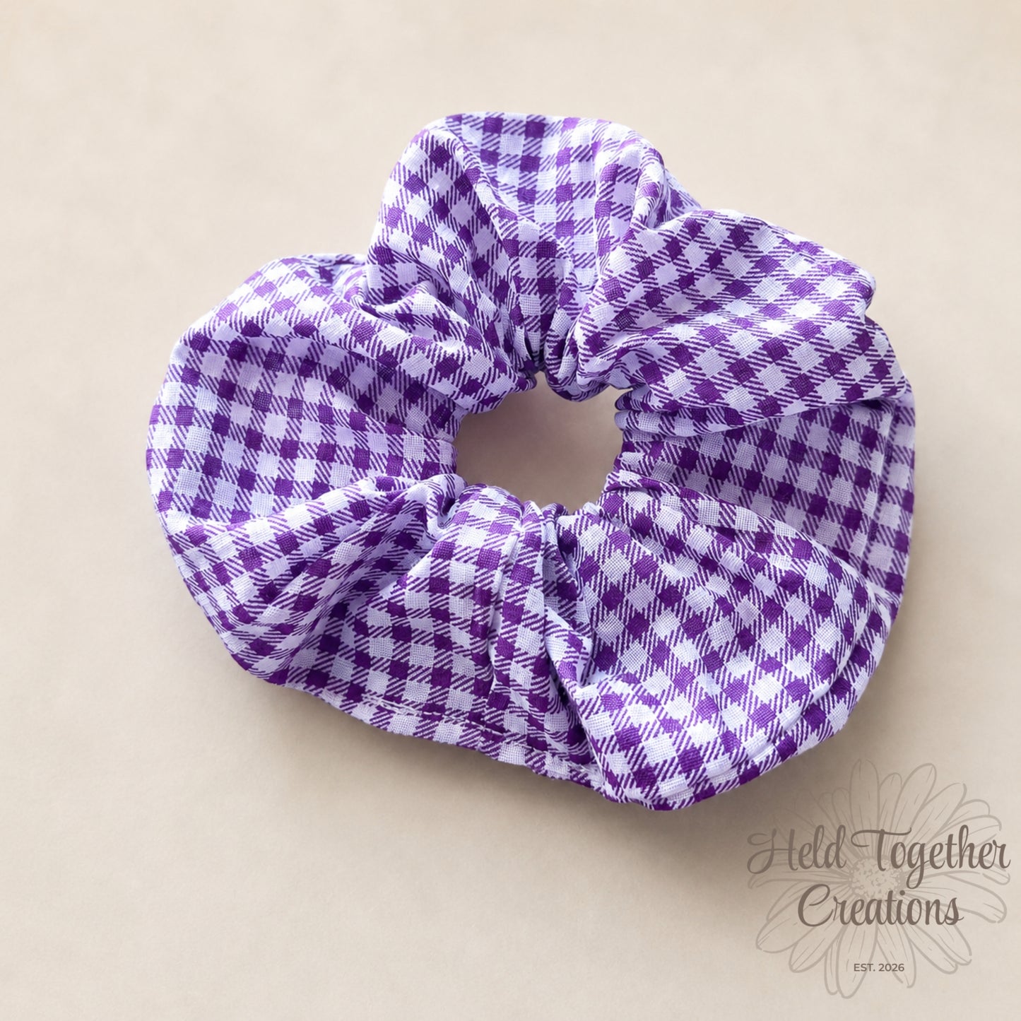Purple and white checkered scrunchie on a beige background