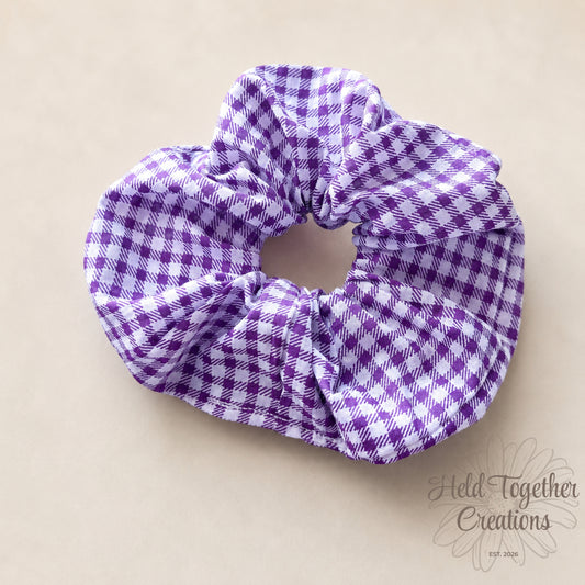 Purple and white checkered scrunchie on a beige background