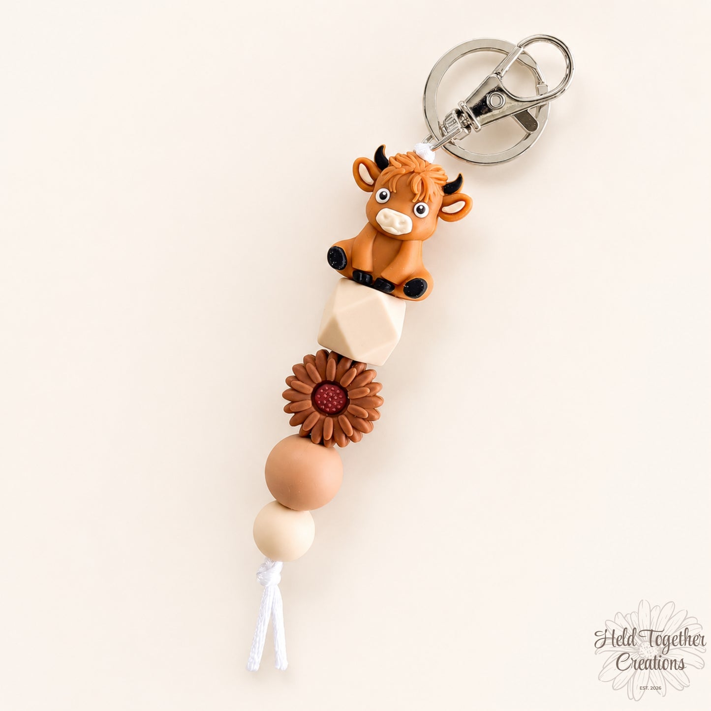 Keychain with cow charm and wooden beads on a white background