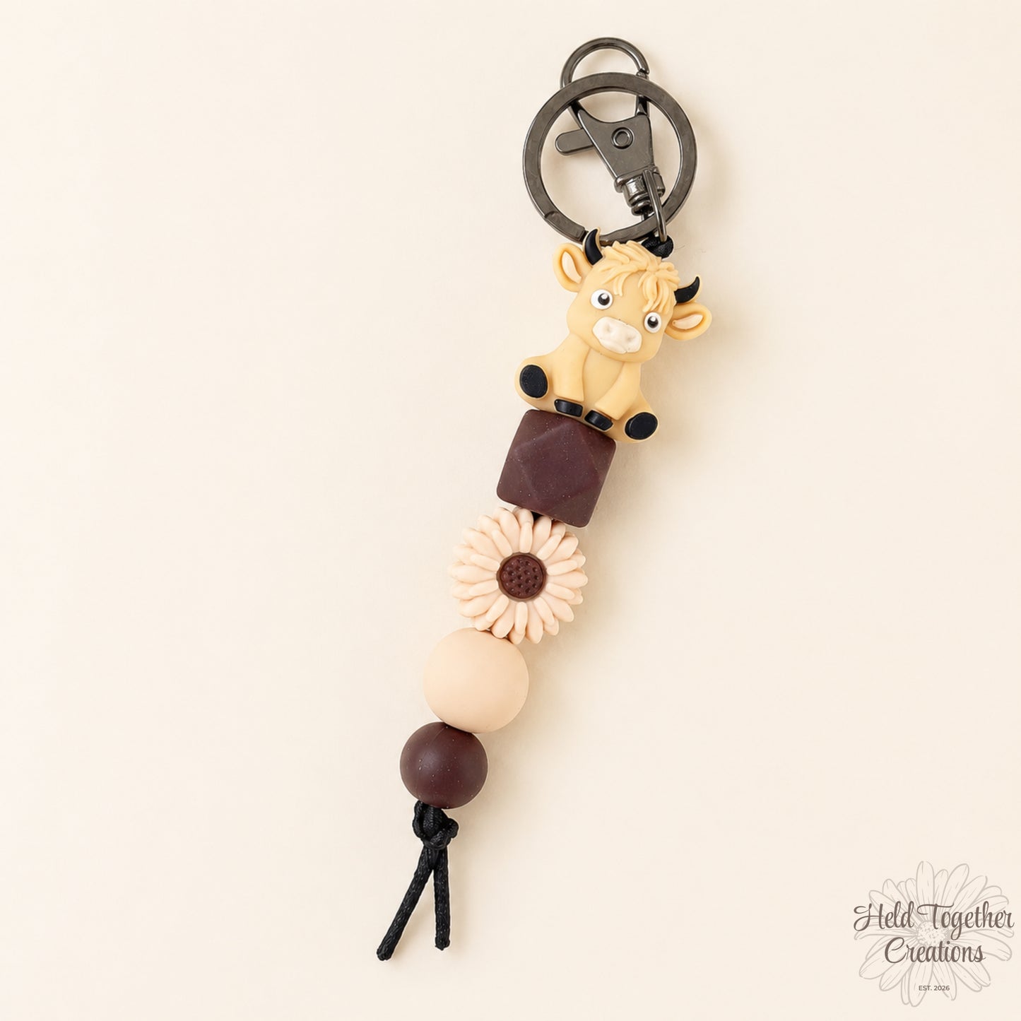 Keychain with animal figure and beads on a beige background